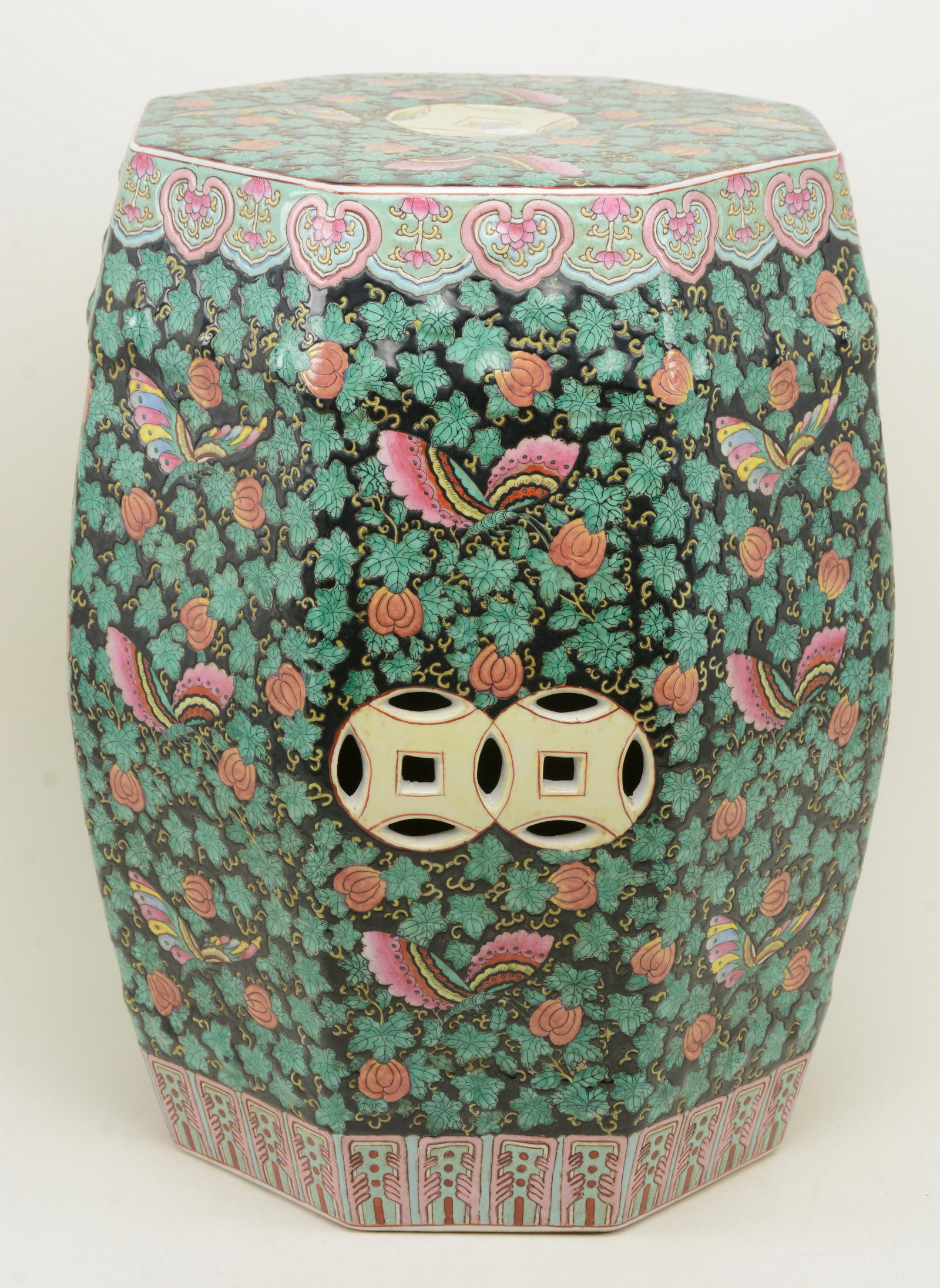 Chinese porcelain octagonal garden seat with foliate: Chinese porcelain octagonal garden seat with foliate and butterfly pattern on a black ground, 20 th Century. Height 18in