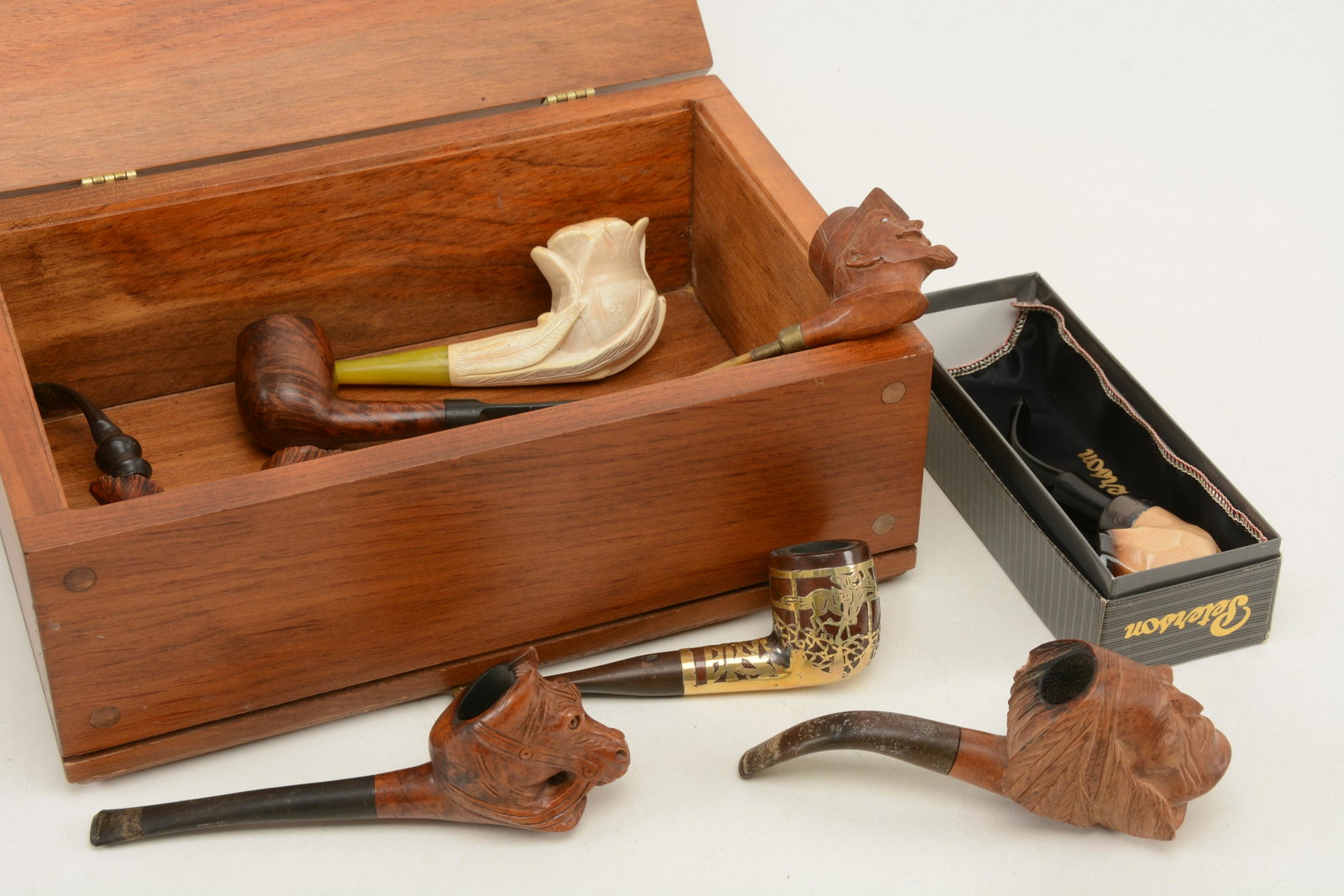 Collection of carved wood smoking pipes. Includes: Collection of carved wood smoking pipes. Includes figural pieces of horse, Native American chief, soldier head, and flower. One labeled Petersonâ€™s of Dublin with sterling silver band in box. Ad