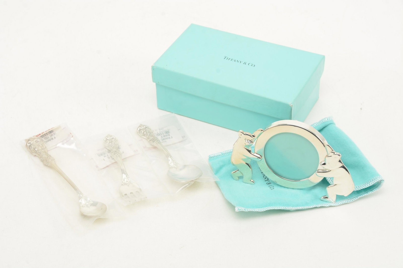 4 Sterling silver child's items. Tiffany & Co. picture: 4 Sterling silver child's items. Tiffany & Co. picture frame with bears and 3 Reed and Barton Frances I flatware pieces, infant feeder and baby spoon and fork. Each item in original box. 4.9 ozt.