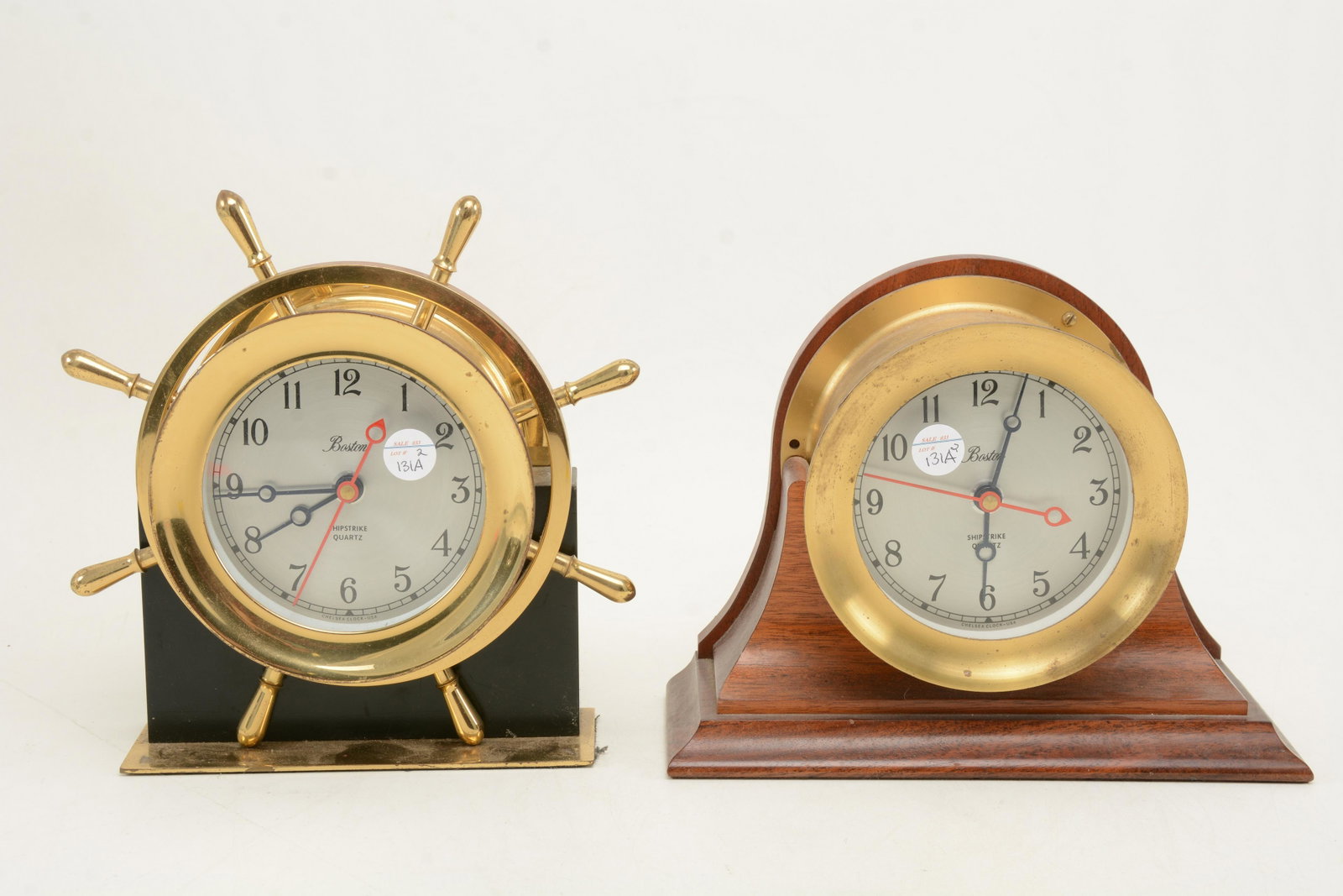 Chelsea Clock Co. Boston ship's Strike brass clocks.: Chelsea Clock Co. Boston ship's Strike brass clocks. One with wooden stand and other in form of a ship's wheel. Time keeping is untested. 7in height x 9in width of clock with stand.