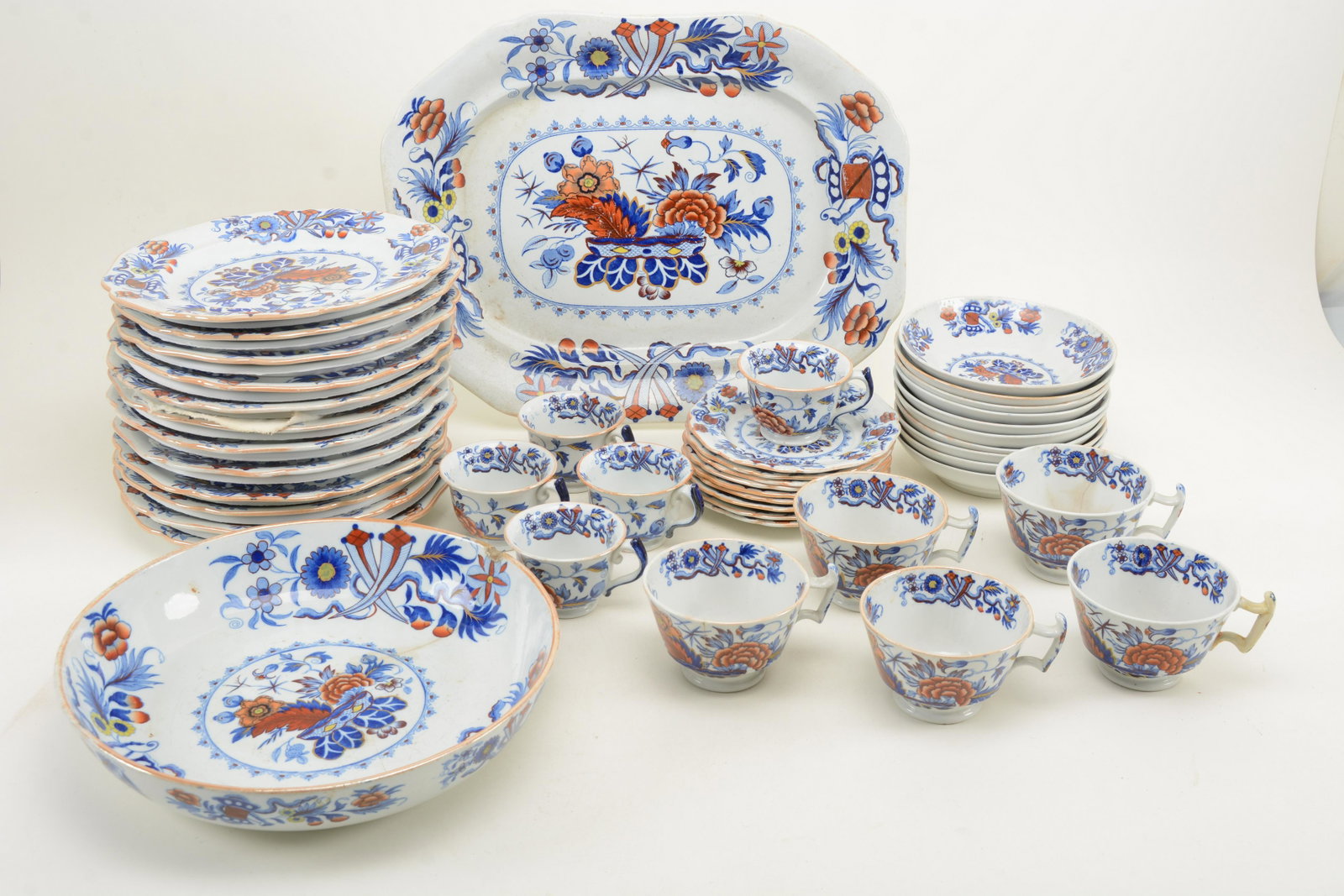 Mid-19th Century Ironstone dinner service with floral: Mid-19th Century Ironstone dinner service with floral decoration. Including 12 dinner plates, 10 large saucers, 7 large, handled cups, 5 teacups, 9 saucers, a shallow circular platter and a rectangula