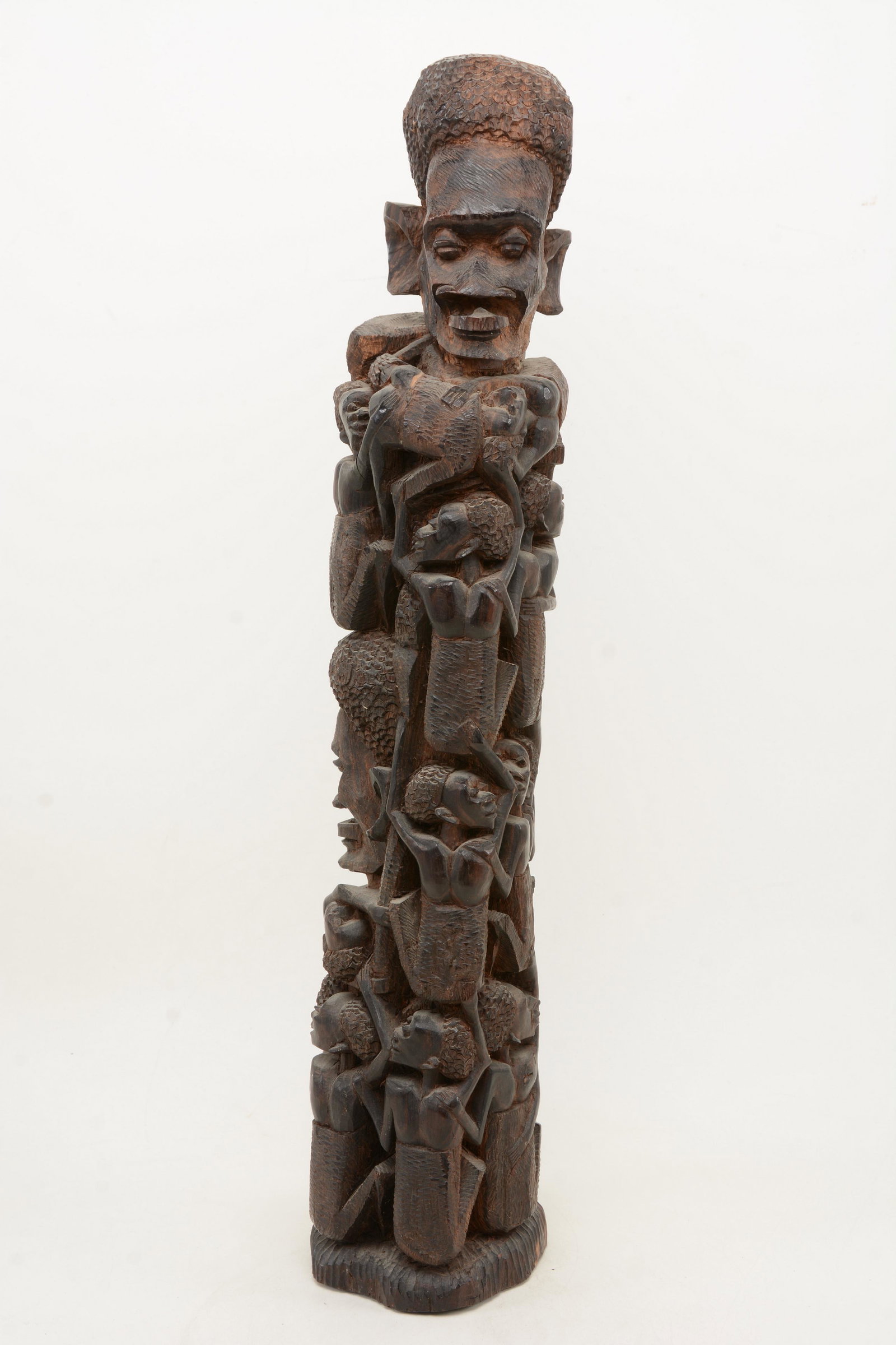 African carved heavy wood totem with faces and figures.: African carved heavy wood totem with faces and figures. Unmarked. 24.5in height.