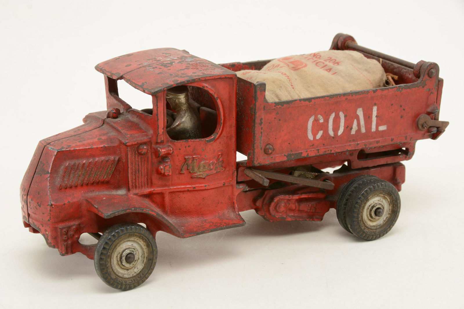 Mack cast iron dump bed coal truck. Complete with: Mack cast iron dump bed coal truck. Complete with original cast driver and retains tailgate. 10 in length.