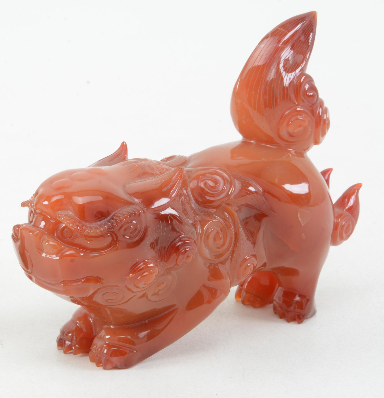 Carved carnelian foo dog. China. 20th century. 6in: Carved carnelian foo dog. China. 20th century. 6in length.