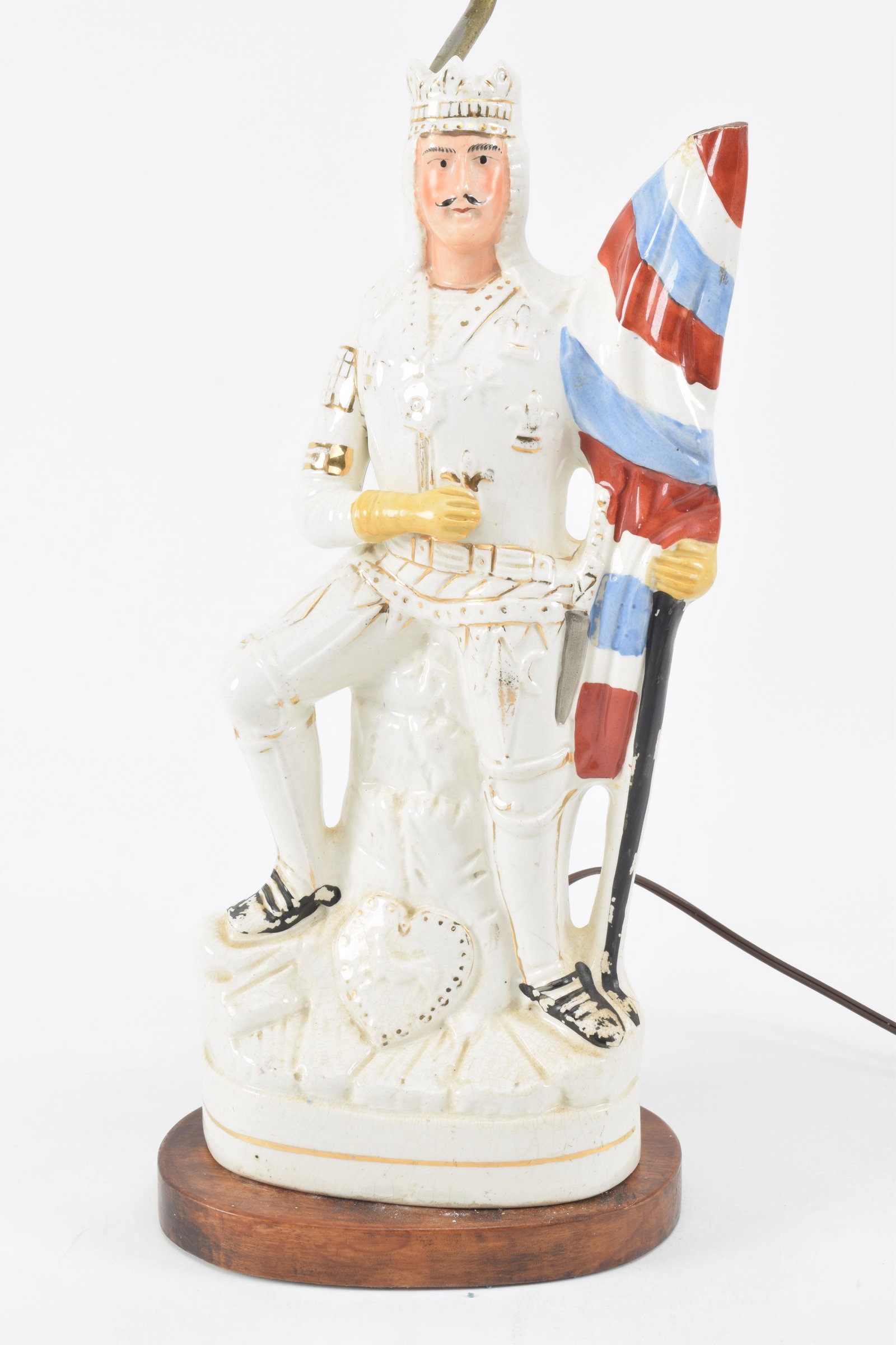 Antique Staffordshire porcelain figure of a French: Antique Staffordshire porcelain figure of a French King. Depicted in regal pose holding a red, white and blue flag and adorned with gilt fleur de lys tabard. Mounted as a lamp. Height of only figure: 