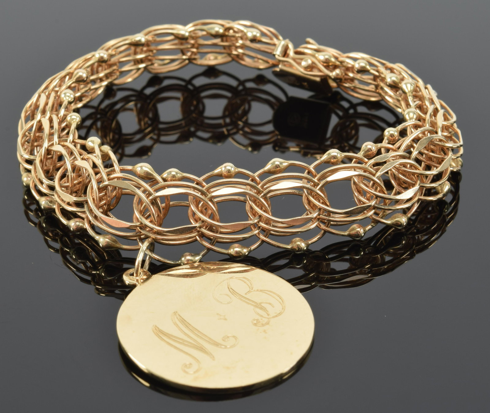 14K gold overlapping link bracelet, suspending a charm,: 14K gold overlapping link bracelet, suspending a charm, engraved, MB. Length, 7.5" 17.0 dwt.