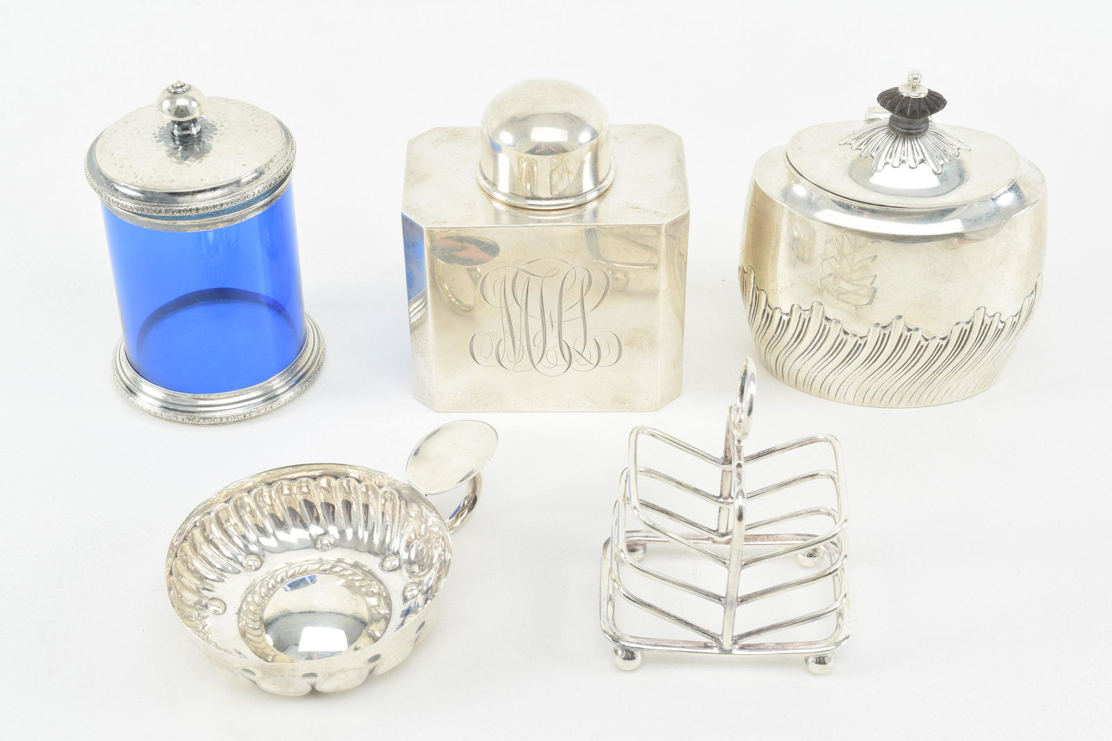 5 piece silver lot. 1) Sterling silver tea caddy. 4in: 5 piece silver lot. 1) Sterling silver tea caddy. 4in high. 2) Oval tea caddy. English. London 1894-5. 3) Antique French silver wine cup. 3in diameter. 4) Scottish sterling silver small toast rack. Ed