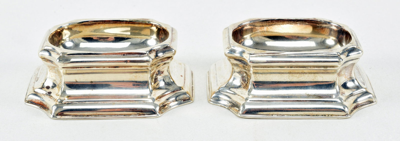 Pair of Georgian sterling silver plinth form salt: Pair of Georgian sterling silver plinth form salt cellars, ca. 1736/37. London. I. W. maker's mark with star burst and quatrefoil elements. 3in wide. 3.46 ozt total weight.