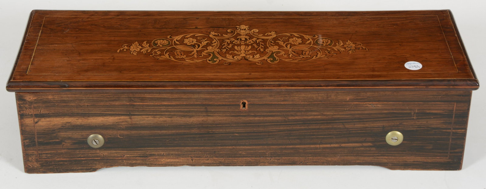 Walnut and grain painted Swiss music box with inlaid: Walnut and grain painted Swiss music box with inlaid top. 13.5" barrel. One tooth missing from right comb. Plays multiple tunes. 5in H x 20.25 W x 7 D. Working condition.