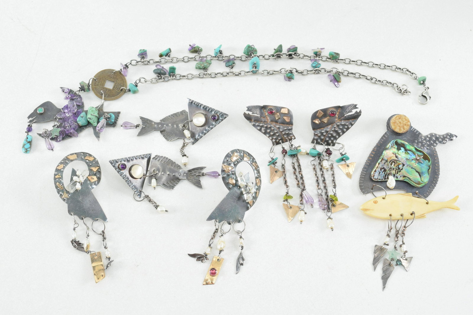 Julie Shaw sterling silver and gold figural designer: Julie Shaw sterling silver and gold figural designer jewelry. To include: 1) Lizard head form earrings with multi strand drops and gold mounts with stone inset eyes. 3in length. 2) Fish form earrings 