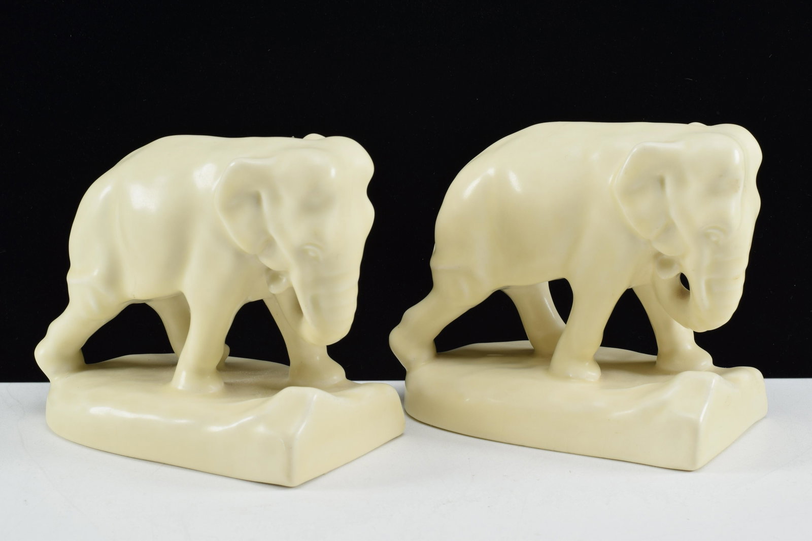 Pair of Rookwood pottery elephant bookends. 1931. Cream: Pair of Rookwood pottery elephant bookends. 1931. Cream colored glaze. Marked to underside. 5.75in wide each.