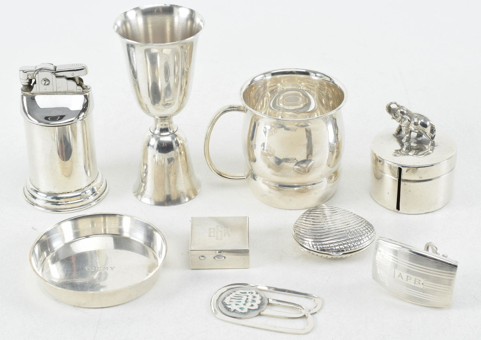 Sterling silver accessories. To include: Gorham table lighter, Towle child's cup, Webster cocktail: Sterling silver accessories. To include: Gorham table lighter, Towle child's cup, Webster cocktail jigger, Gorham ring dish, pill box, monogrammed buckle, money clip, shell form box, and box with elep