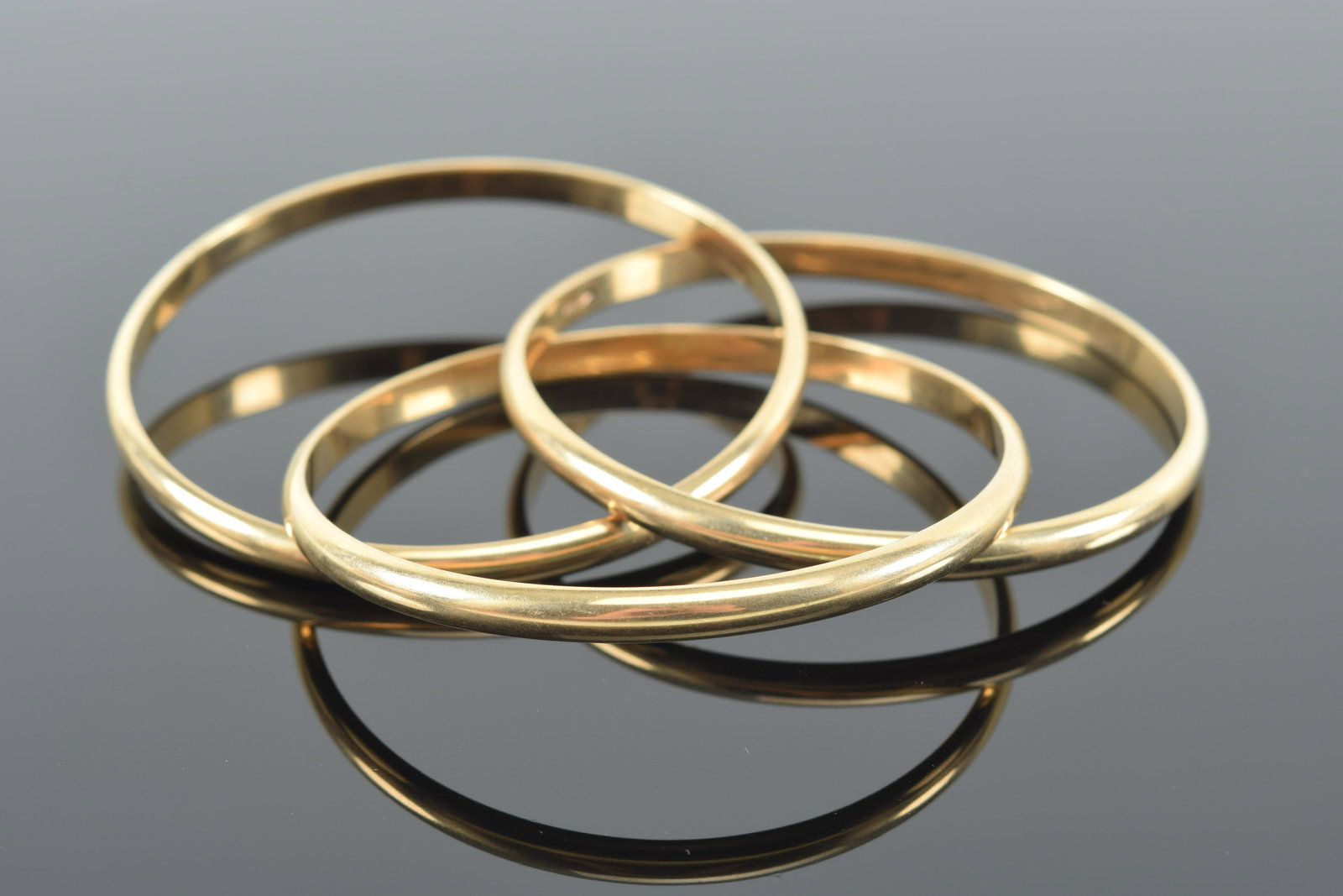 3 14K gold interlocked round bangle bracelets. 2.375in opening diameter. Marked 14K. 27.4 grams. (1 of 4)