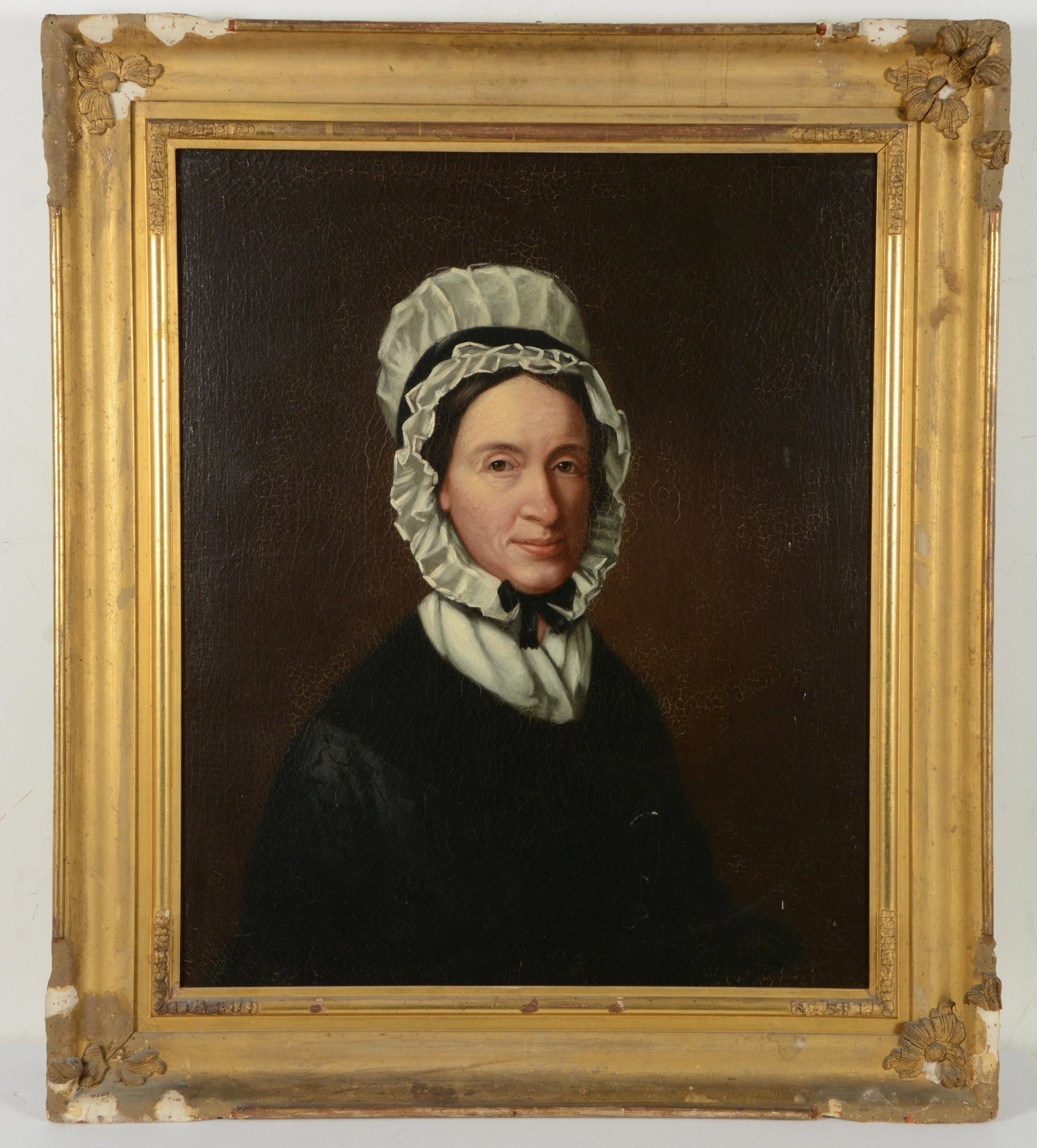 Early 19th century American school portrait of a woman wearing a bonnet. Ca. 1830. Oil on canvas. In: Early 19th century American school portrait of a woman wearing a bonnet. Ca. 1830. Oil on canvas. In the original frame. Label on reverse: "Elizabeth Hall Gray". Relined. Allover craquelure. Losses to