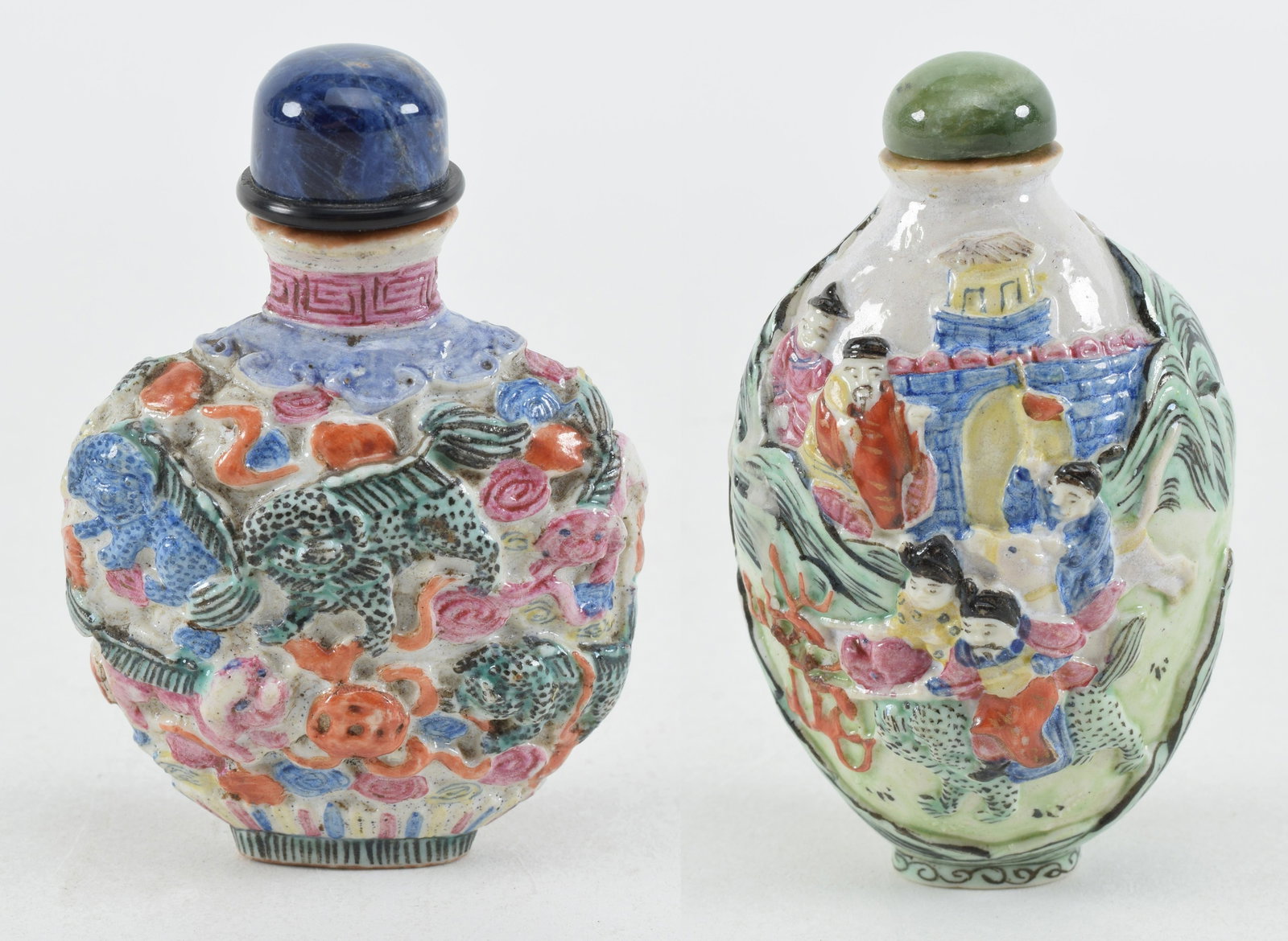 2 porcelain snuff bottles. China. 19th century. Moulded decoration of an historical scene and the: 2 porcelain snuff bottles. China. 19th century. Moulded decoration of an historical scene and the other with foo dogs. Chien Lung marks. 3.25 and 2.5in.