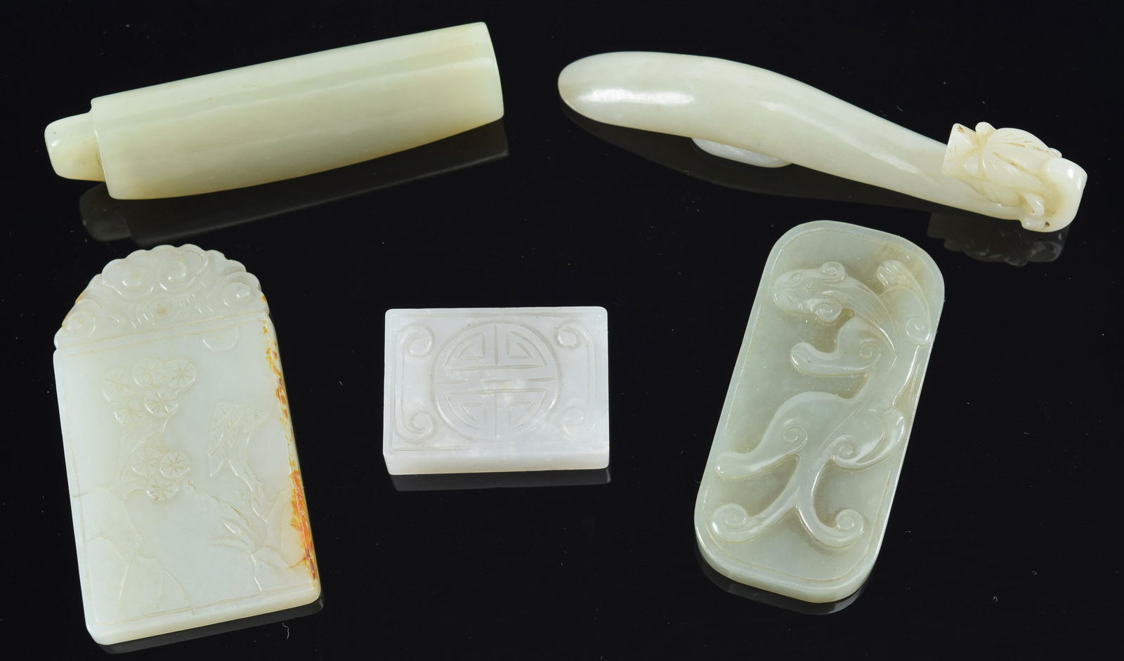 5 jade carvings. China. 19th/20th century. To include: plume holder, garment hook, and 3 pendants. (1 of 8)