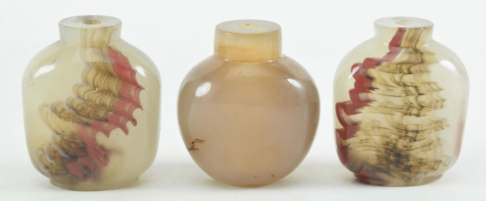 Lot of 3 Chinese snuff bottles. 1) Pair of 19th century imitation agate peking glass bottles with: Lot of 3 Chinese snuff bottles. 1) Pair of 19th century imitation agate peking glass bottles with blood red veins. 2.25in high. 2) Rust veined agate decorated bottle.