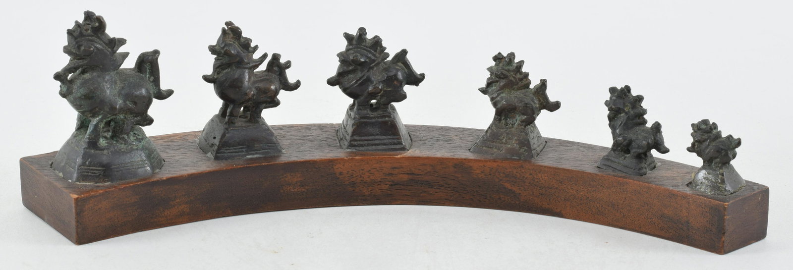 Graduated set of Burmese measurement weights. Bird form finials. Mounted on a wooden frame. Largest: Graduated set of Burmese measurement weights. Bird form finials. Mounted on a wooden frame. Largest 2.5in. Overall length: 11in.
