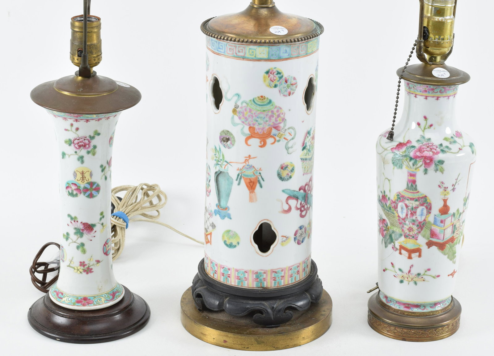 Lot of 3 porcelains. China. Early 20th century. 2 vases and a hatstand. Famille rose decoration of: Lot of 3 porcelains. China. Early 20th century. 2 vases and a hatstand. Famille rose decoration of the hundred antiques and floral motifs. Each about 10in high. Drilled and mounted as lamps.