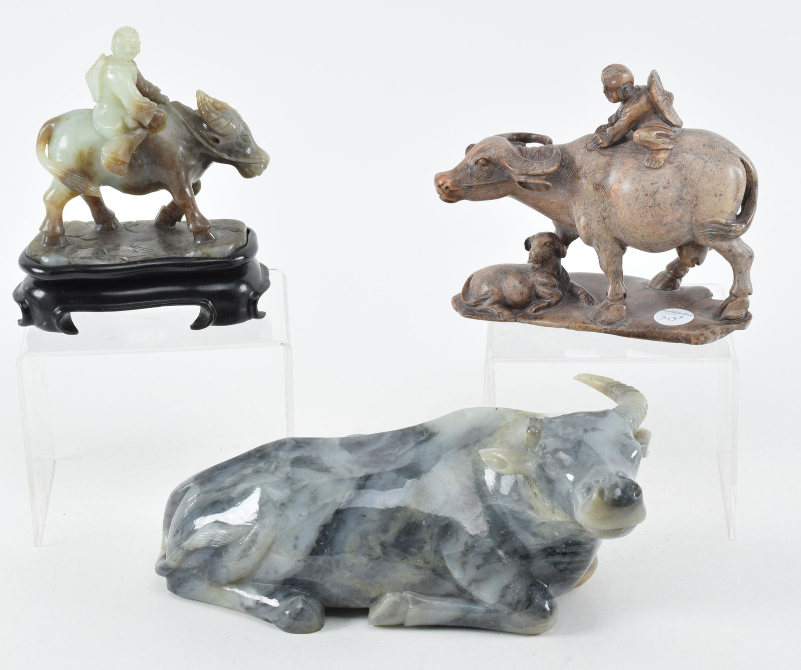 Lot of 3 carvings. China. 20th century. Three water buffaloes, 2 with children. 2 jade and one (1 of 10)