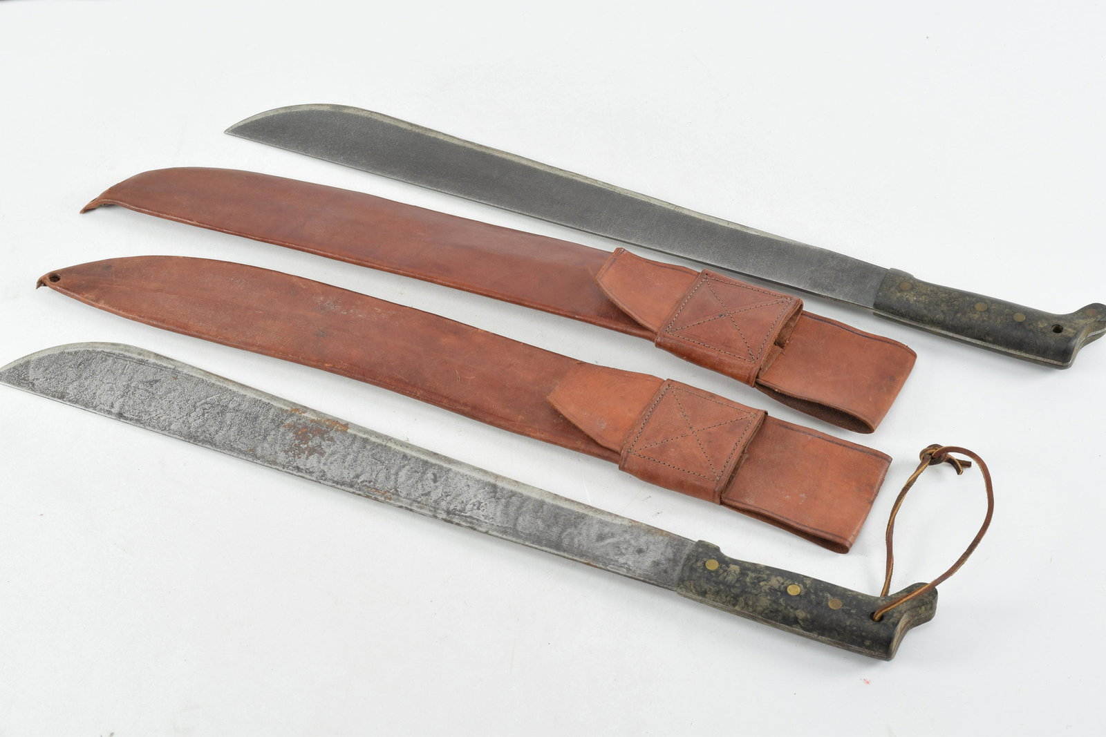Lot of two Legitimus Collins and Co Machetes with Leather Scabbards. Both of these same type: Lot of two Legitimus Collins and Co Machetes with Leather Scabbards. Both of these same type machetes have 18" blades and their scabbards are both ink stamped #115. One blade is ink stamped #172. Both