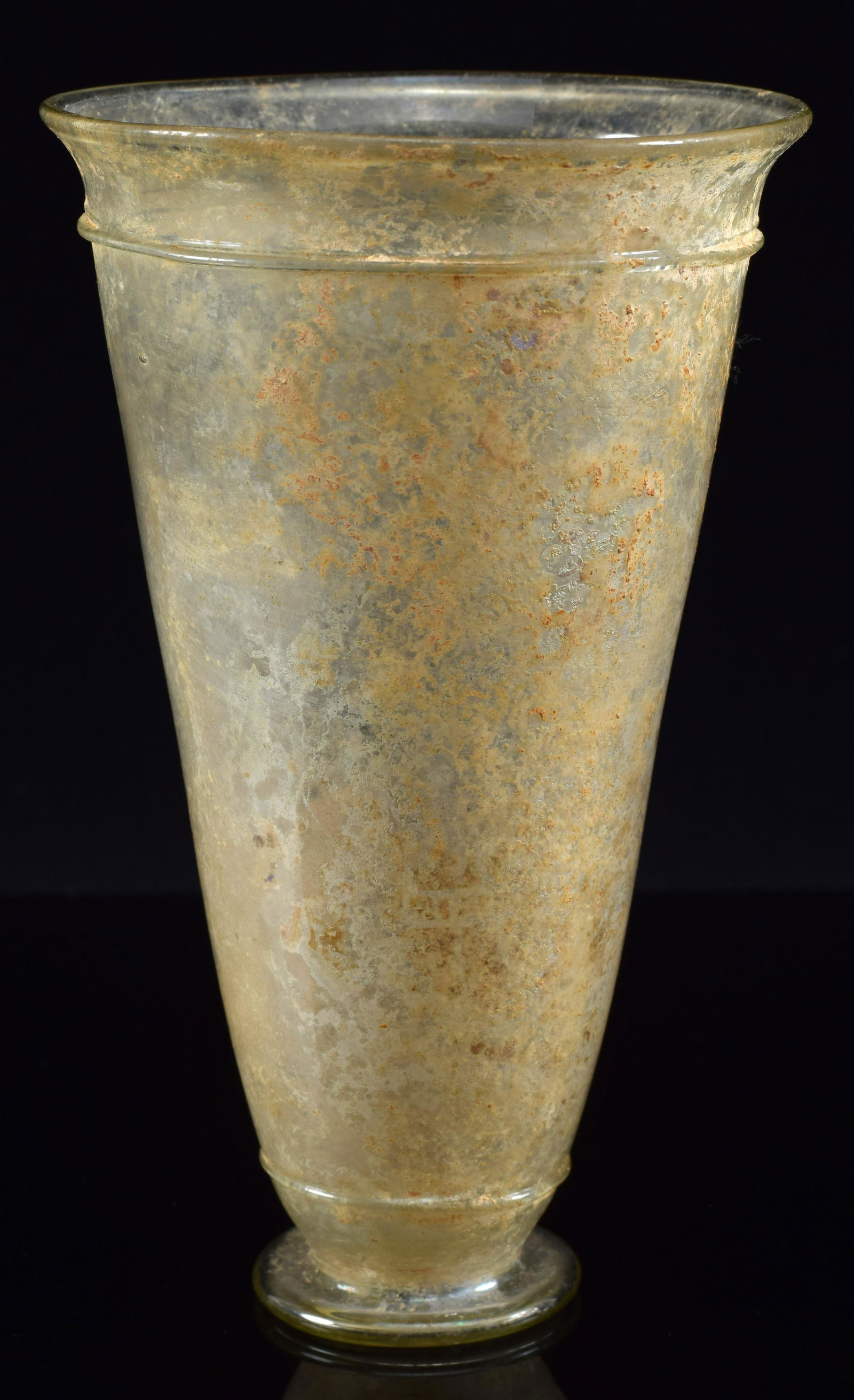 Ancient Roman glass footed cup. Conical form. Flared rim. Light yellow/clear in color. 5.25in: Ancient Roman glass footed cup. Conical form. Flared rim. Light yellow/clear in color. 5.25in height.