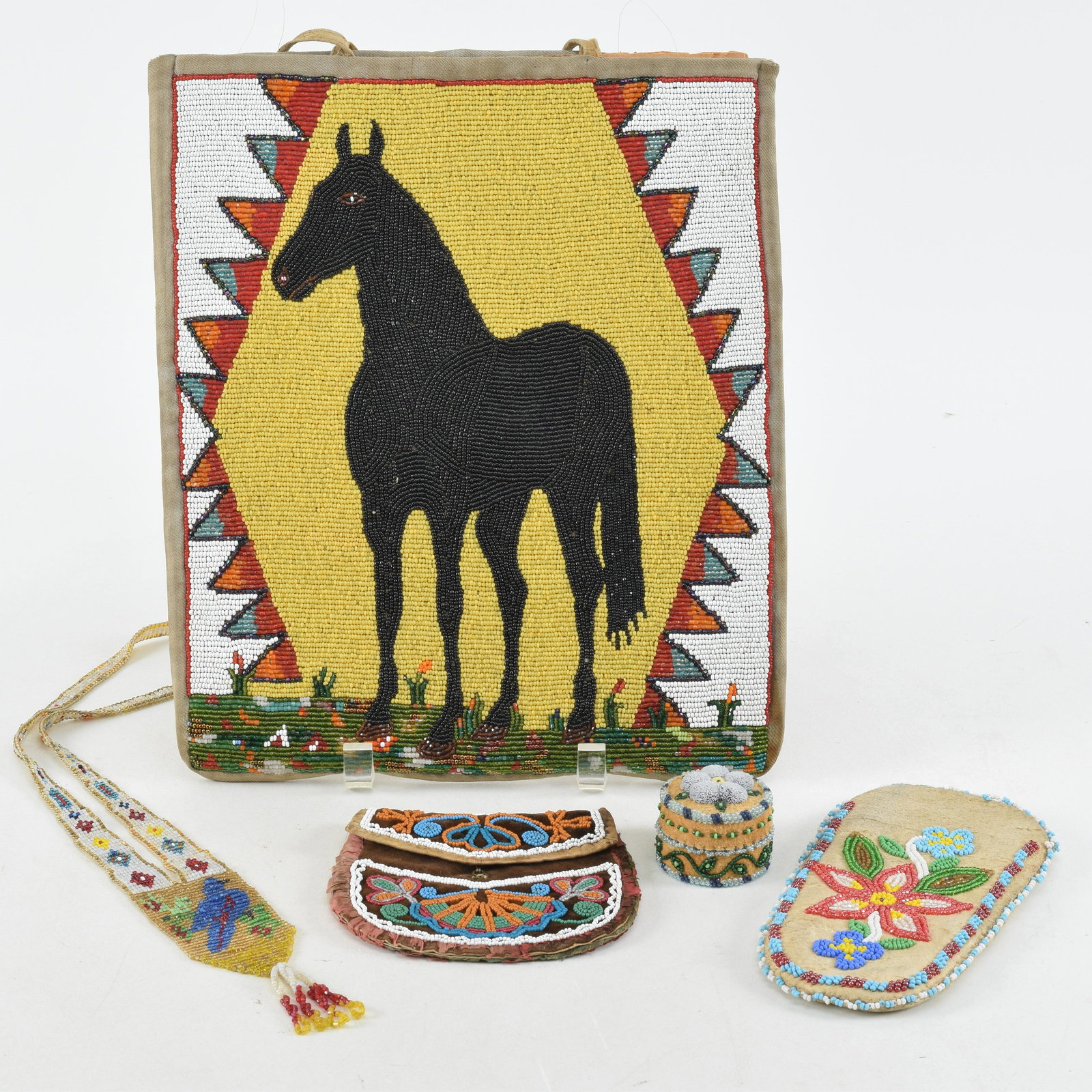 Native American Indian beadwork. 4 total pieces, all ca. 1920. Including parflech with a beaded deco: Native American Indian beadwork. 4 total pieces, all ca. 1920. Including parflech with a beaded decoration of a black horse on yellow ground. Largest 12in length.