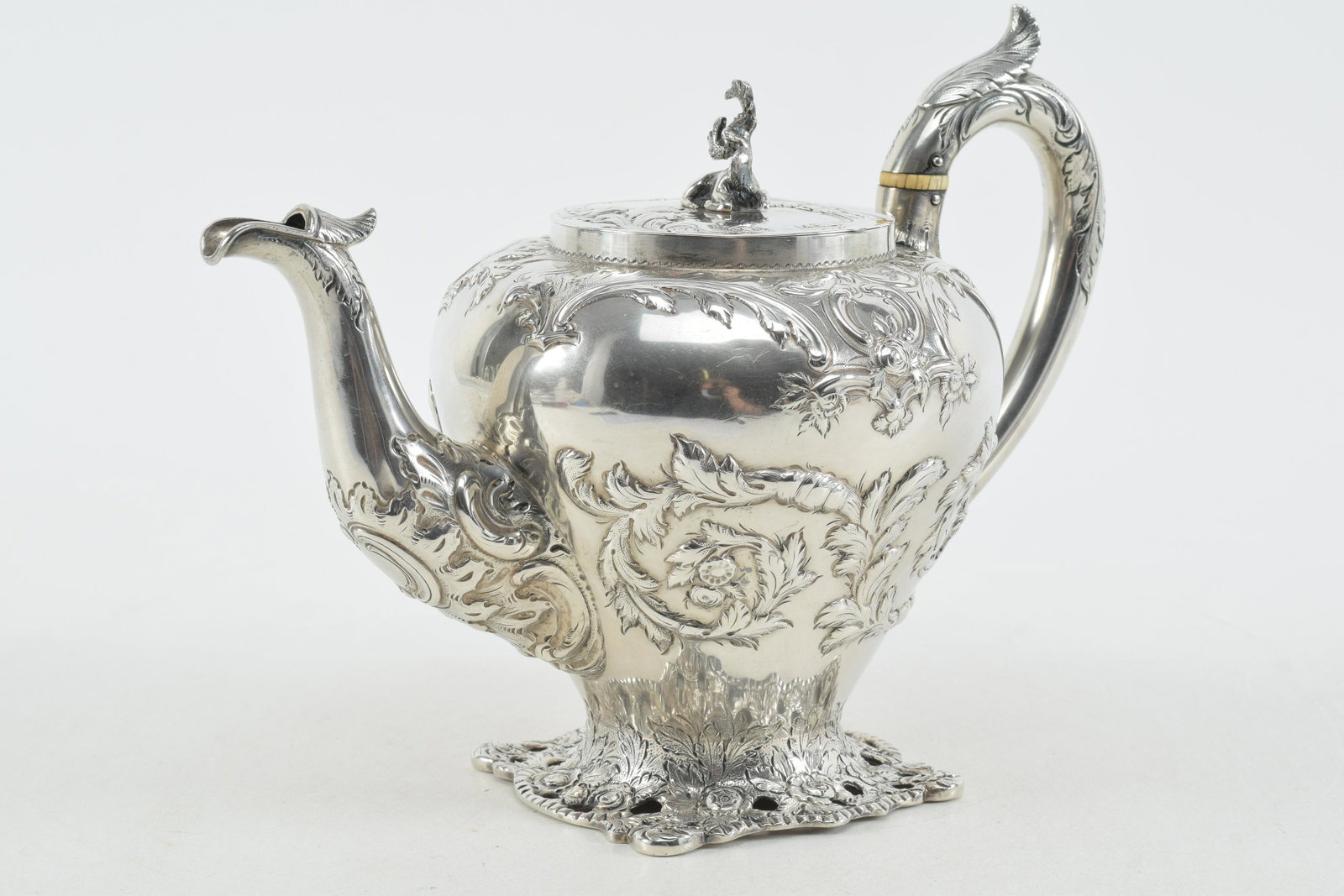 S. Kirk & Son early 19th century sterling silver pierced platform base teapot with figural stag: S. Kirk & Son early 19th century sterling silver pierced platform base teapot with figural stag finial. Floral garland repousse decoration. Armorial crest on cover. Marked on base with name and 11oz m