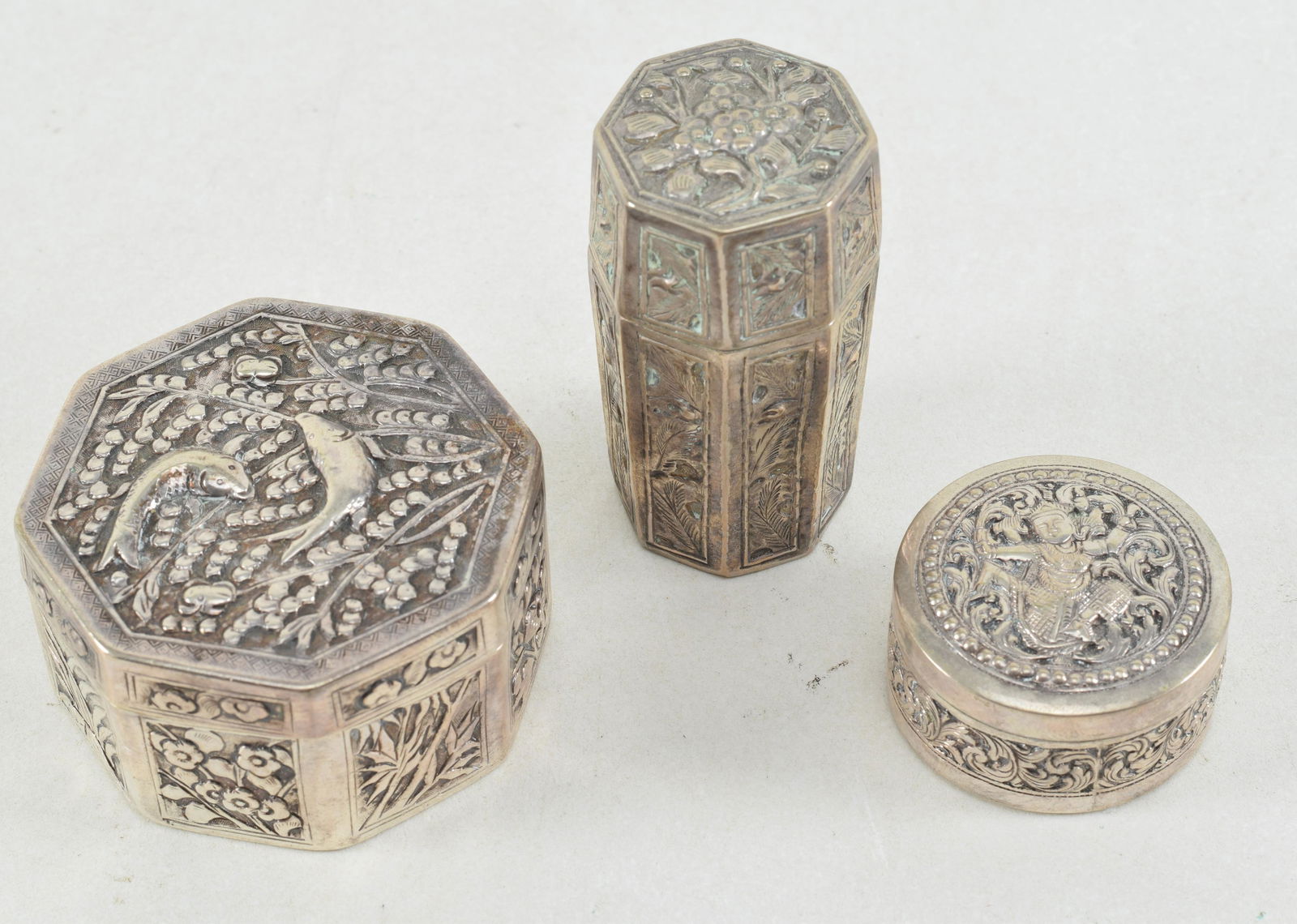 3 pieces of Asian silver. 1) Chinese export octagonal covered box with repousse decoration of fish (1 of 7)