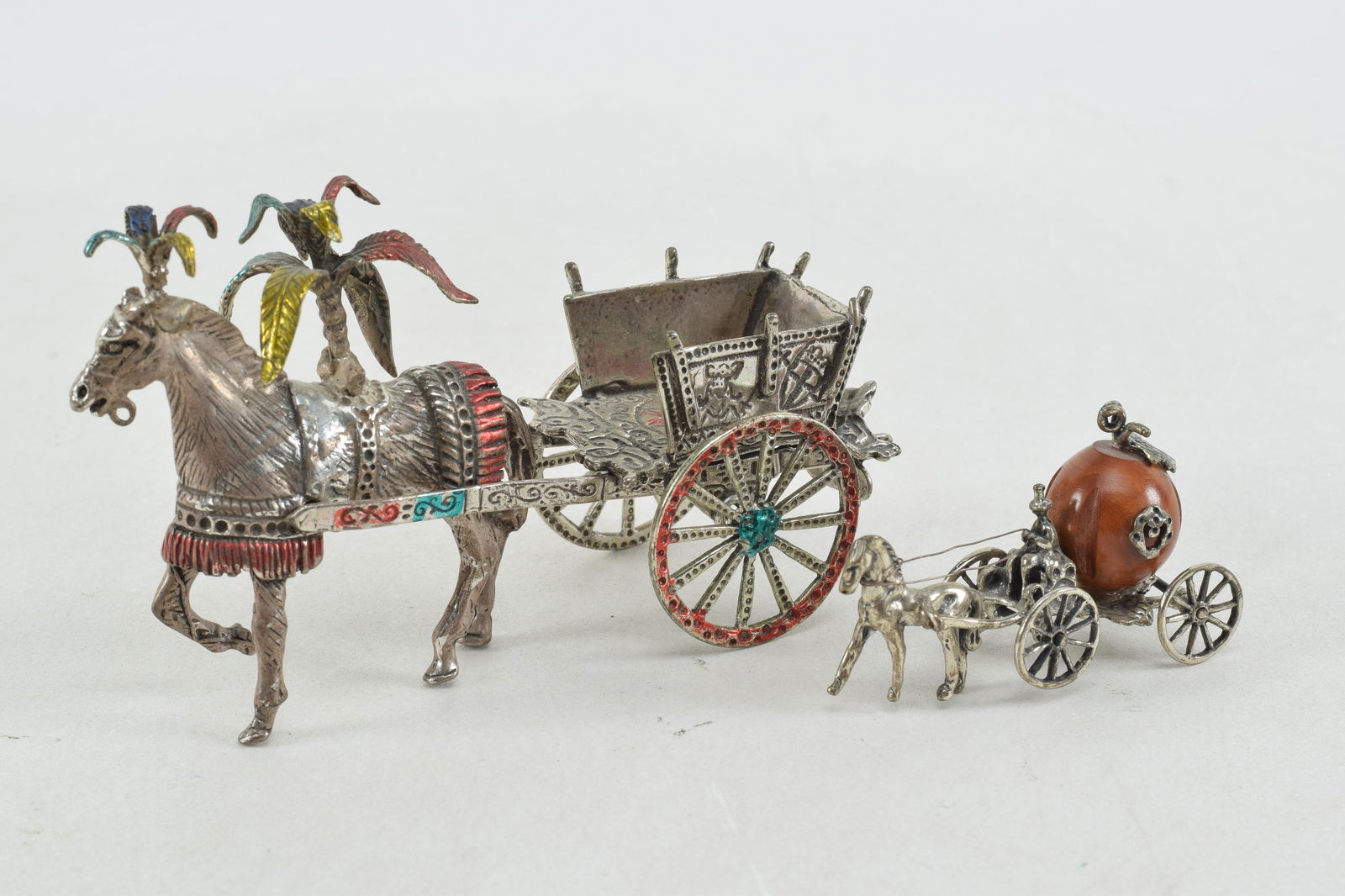 2 Continental silver miniature wagons. 1) Small heavy pony driven cart with paint decorated wheels: 2 Continental silver miniature wagons. 1) Small heavy pony driven cart with paint decorated wheels and leaves. 4.75in long. 4 ozt. Marked .800 on wagon rail. 2) Small 4 wheel horse drawn wagon with dr