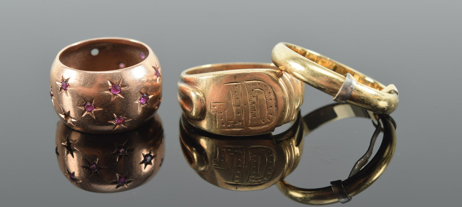 3 gold rings. 1) 14K rose gold star design ruby mounted band. Marked 14K. 2) 14K marked monogram (1 of 7)