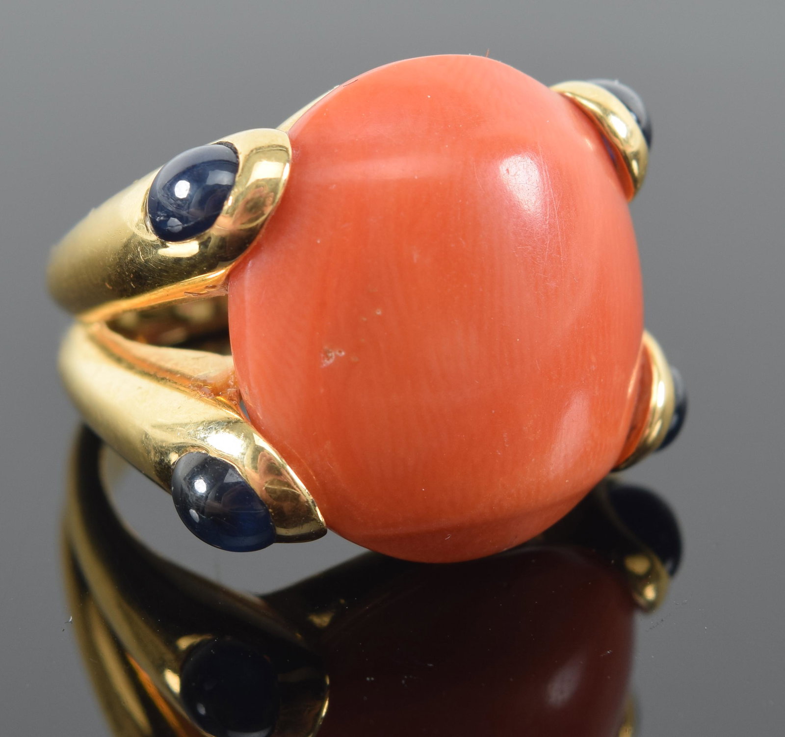 18K gold heavy coral mounted ring. Marked 750. Approx ring size 6. Coral stone 5/8in wide. 16.3: 18K gold heavy coral mounted ring. Marked 750. Approx ring size 5.75/6. Coral stone 5/8in wide. 16.3 grams.