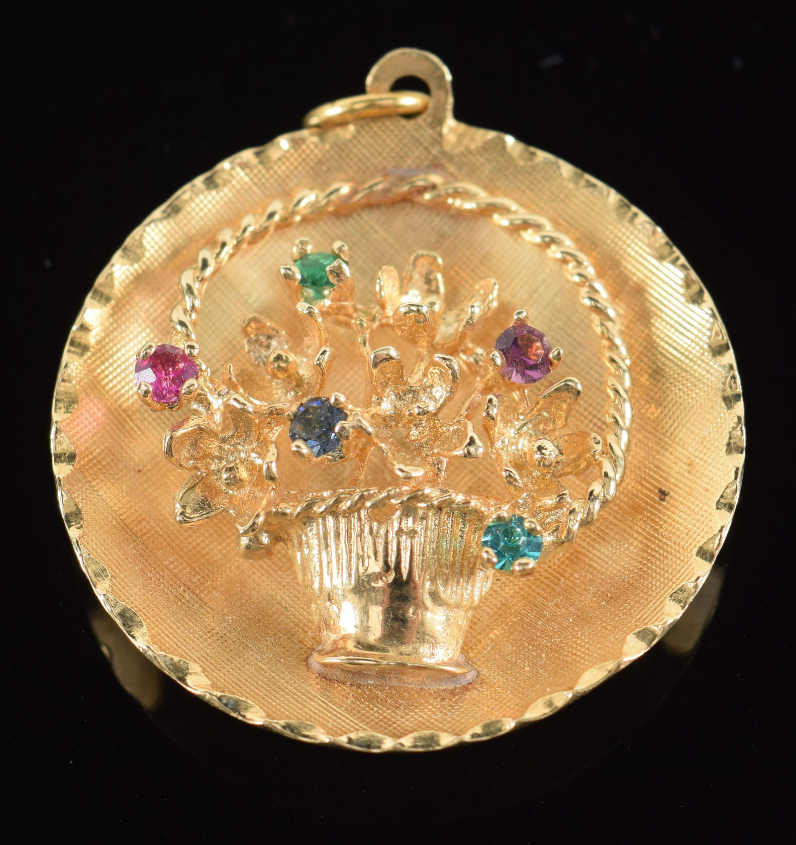 14K gold round pendant with basket of flowers decoration. Mounted stones. Marked 14K. 1in diameter. (1 of 4)