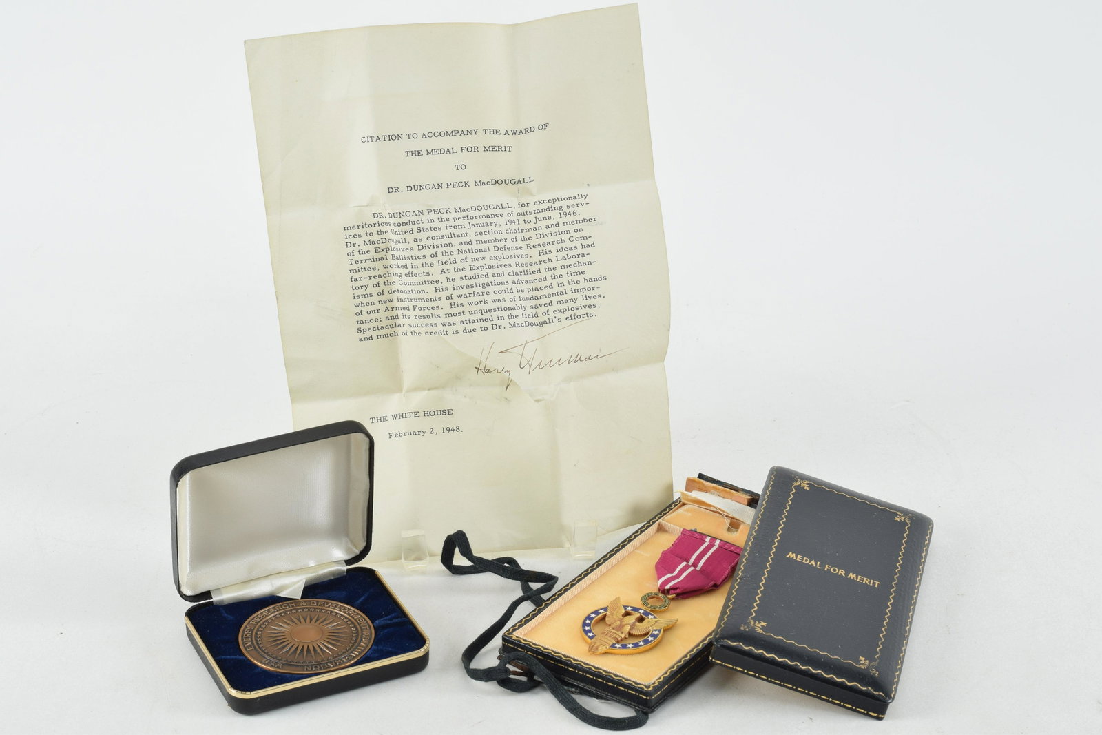 3 piece lot. U.S. medal of merit with pen signed Harry Truman letter and bronze Distinguished: 3 piece lot. U.S. medal of merit with pen signed Harry Truman letter and bronze Distinguished Associate Award, 1976. These items were presented to Duncan P. MacDougall. the Medal of Merit presented in