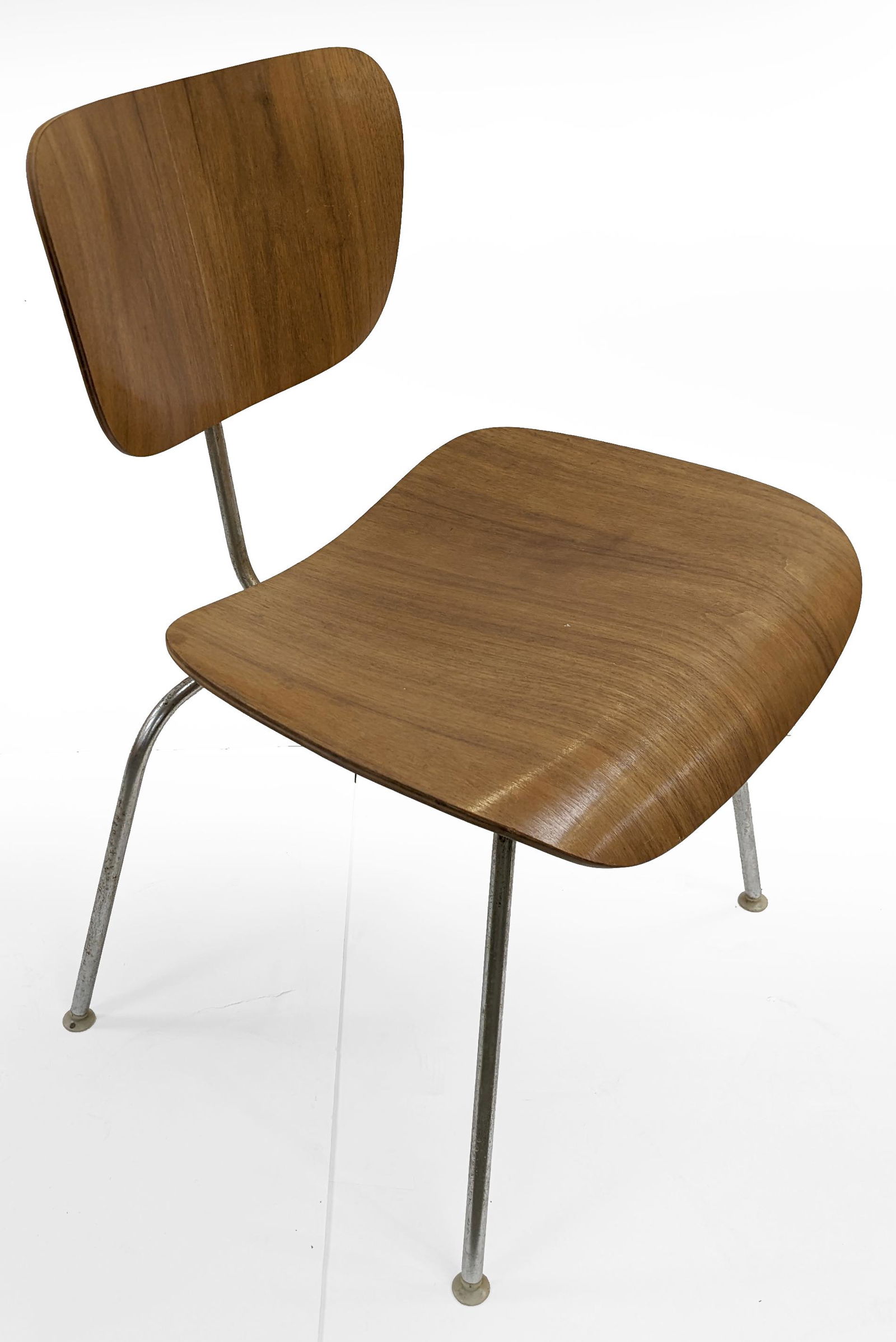 Charles Eames for Herman Miller mid century modern molded plywood side chair. Original label on unde: Charles Eames for Herman Miller mid century modern molded plywood side chair. Original label on underside. Light surface rust on legs. One brace on backrest slightly loose. 30 H x 19.5 W x 22in D.