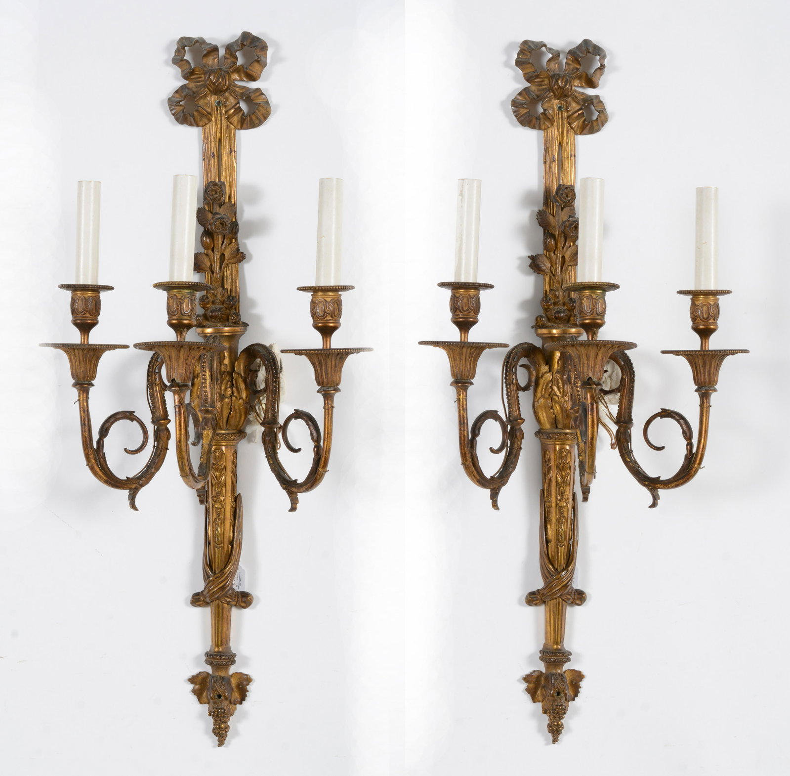 Pair of 19th/20th century French gilt bronze 3 light wall sconce candelabra. Bow knot and floral: Pair of 19th/20th century French gilt bronze 3 light wall sconce candelabra. Bow knot and floral decoration. Later electrified. Signed on back. 28in long.