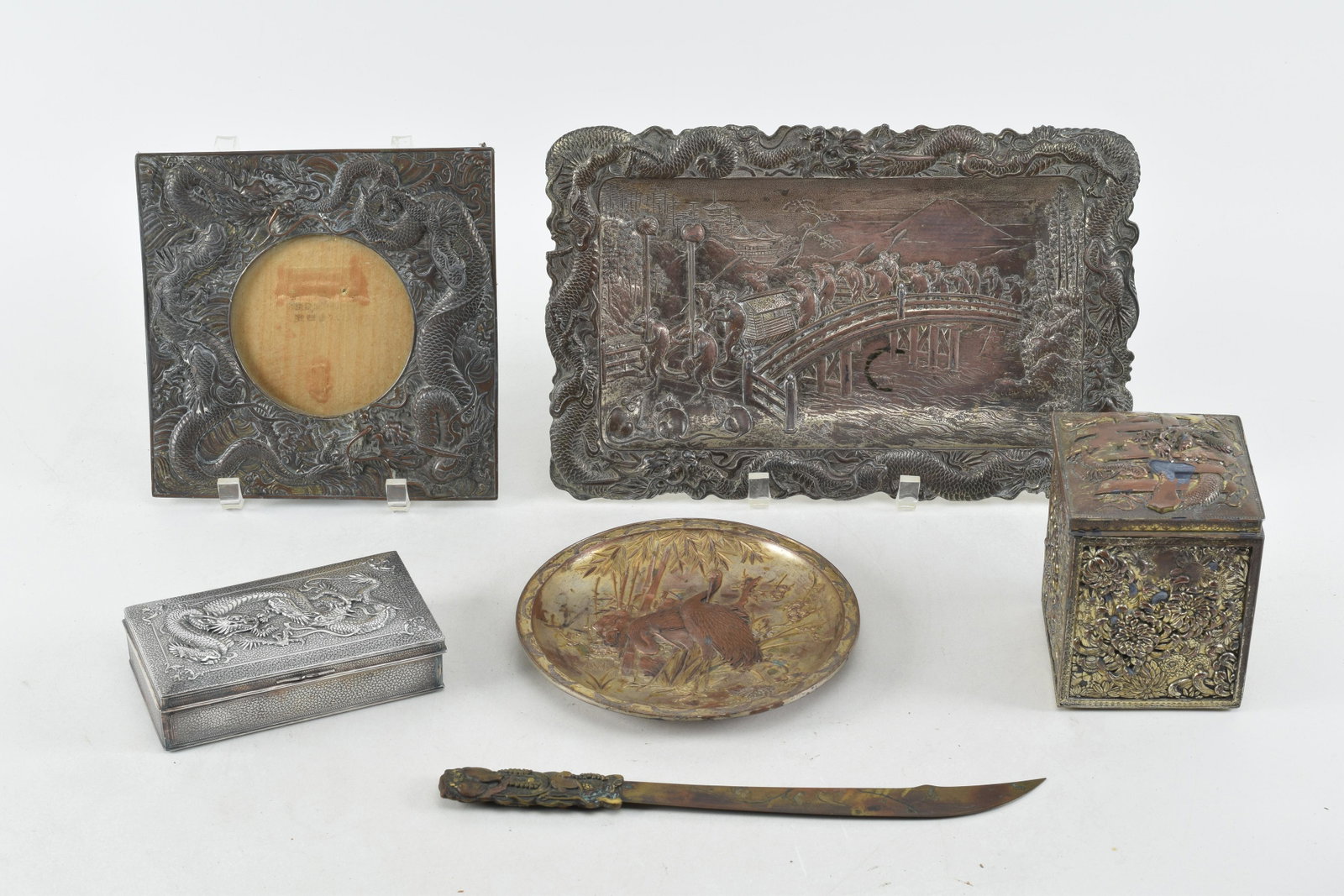 Collection of Japanese and Chinese mixed metal and plated silver decorative items. Includes open: Collection of Japanese and Chinese mixed metal and plated silver decorative items. Includes open dish with crane, letter opener, dragon cigarette box, Dragon picture frame, chrysanthemum covered box, 