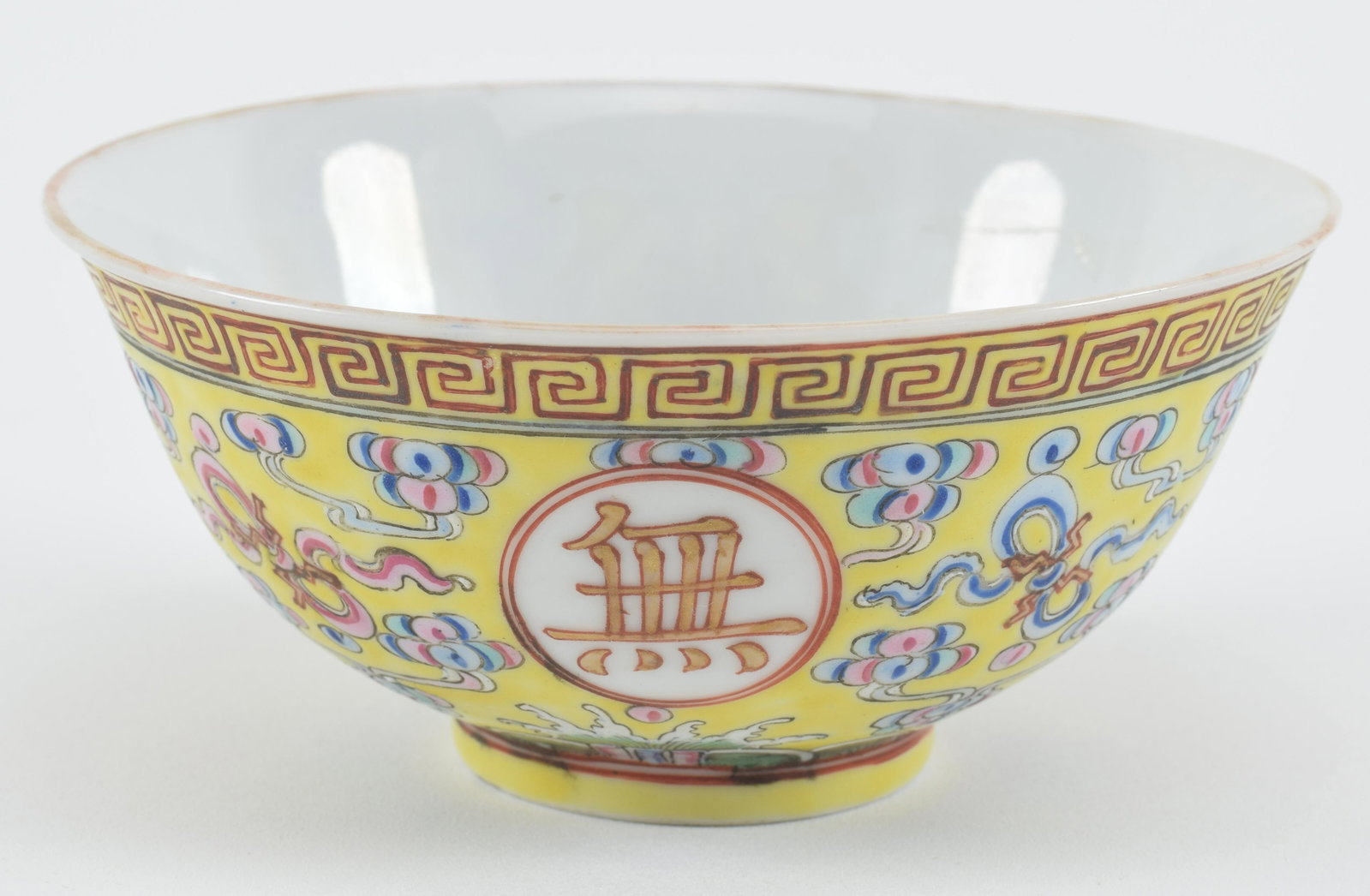 Chinese yellow ground famille rose decorated porcelain bowl with rust bats on interior. Guang Xu: Chinese yellow ground famille rose decorated porcelain bowl with rust bats on interior. Guang Xu mark on base. 5in diameter.