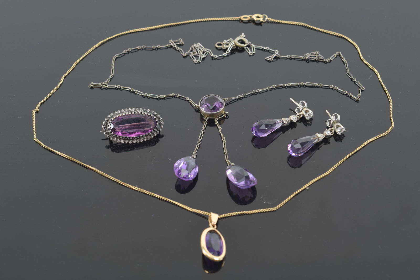Lot of amethyst jewelry. 1) 14K gold diamond mounted drop earrings. Tests as 14K. 1.2in long. 2) 14K (1 of 7)