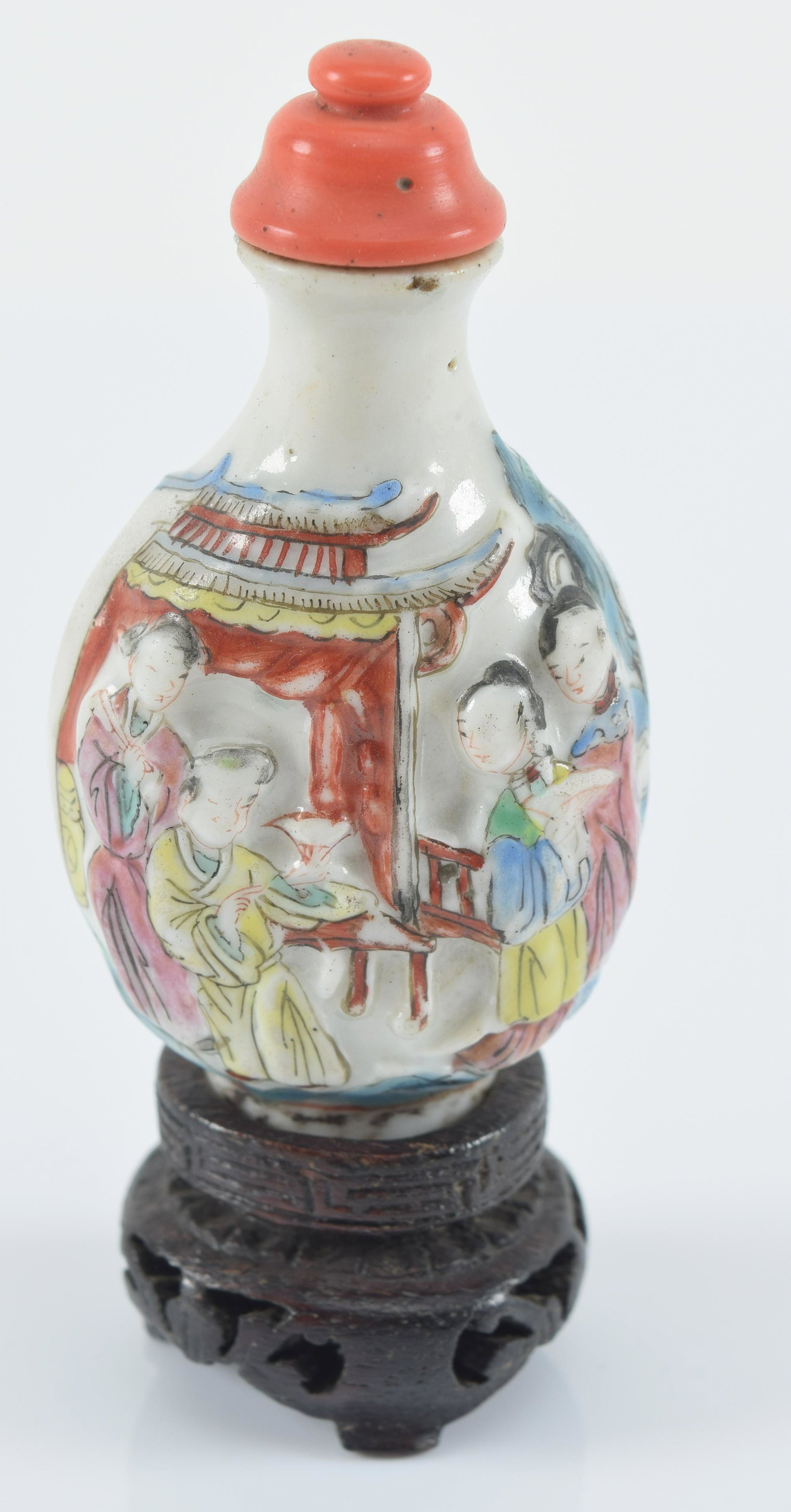 Porcelain snuff bottle. China. Chien Lung period (1736-1795). Relief decoration. Carved coral top.: Porcelain snuff bottle. China. Chien Lung period (1736-1795). Relief decoration. Carved coral top. Fitted stand. 2.25in high.