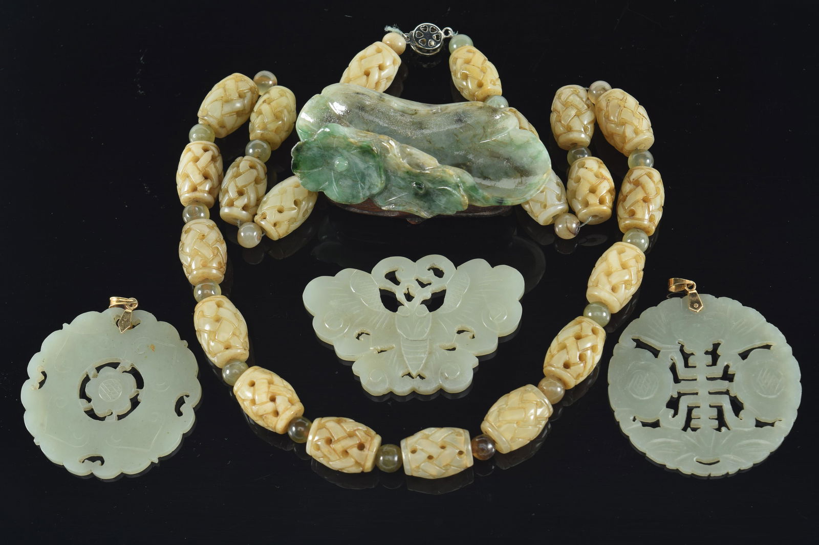 Lot of 5 jades. China. 20th century. To include: 3 pendants, an "endless knot" carved necklace, and (1 of 5)