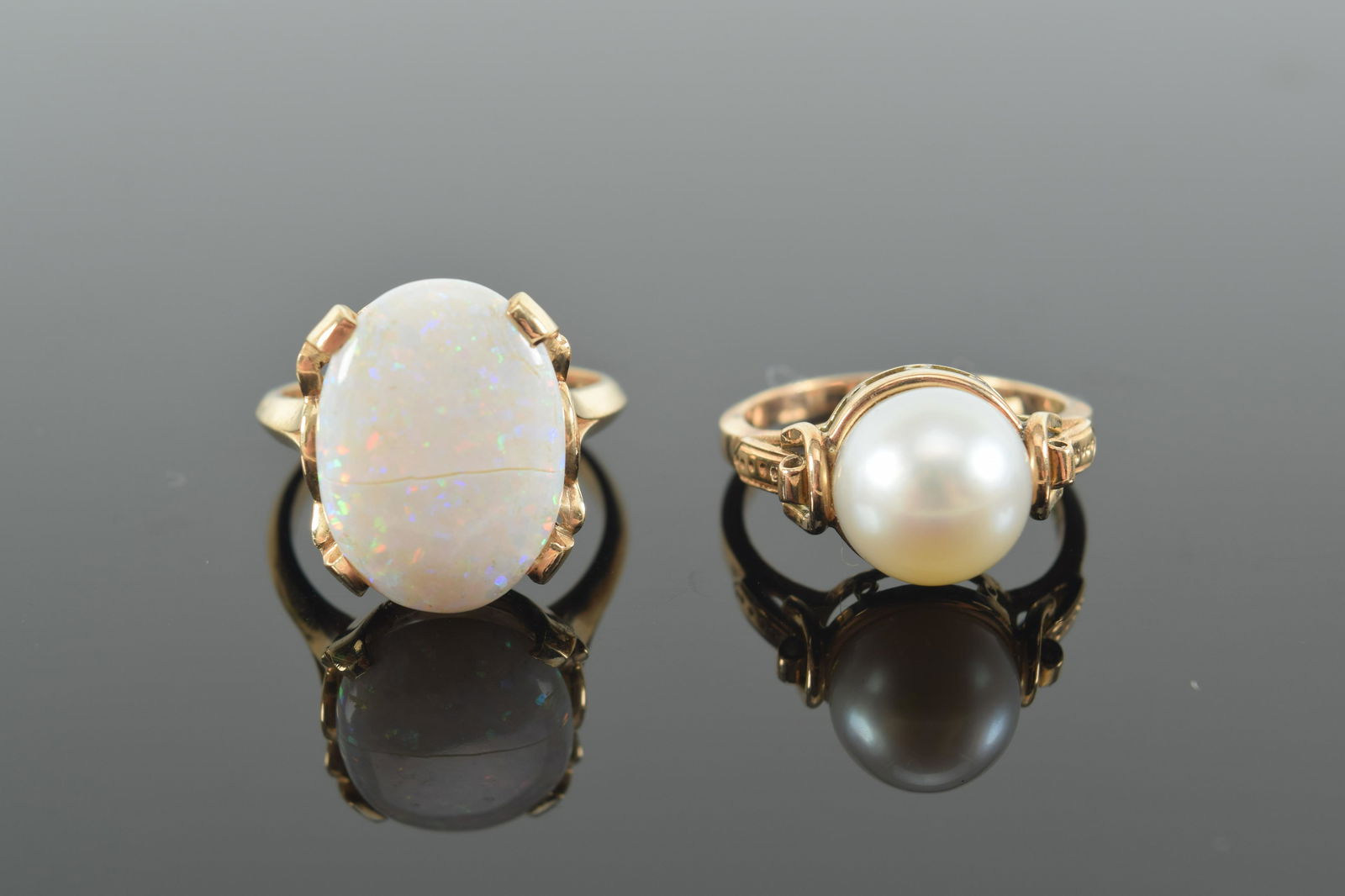 2 14K gold rings. 1) Large oval opal. Marked 14K. Opal 0.6in long. Cracked. 6.25 ring size. 2) Pearl (1 of 6)