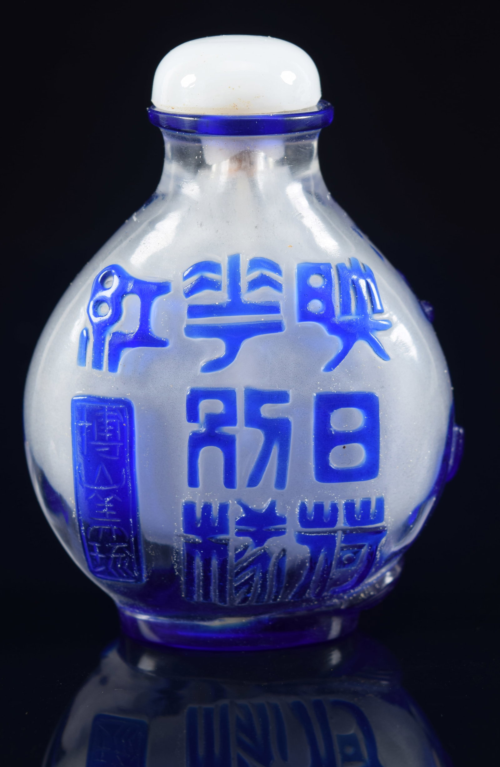 Glass snuff bottle. China. 19th century. Cameo overlay of blue on clear. Decoration of archaic: Glass snuff bottle. China. 19th century. Cameo overlay of blue on clear. Decoration of archaic characters and flowering lotus plants. Glass stopper. 2.5in. Provenance: The Mitchell Bistany Collection.