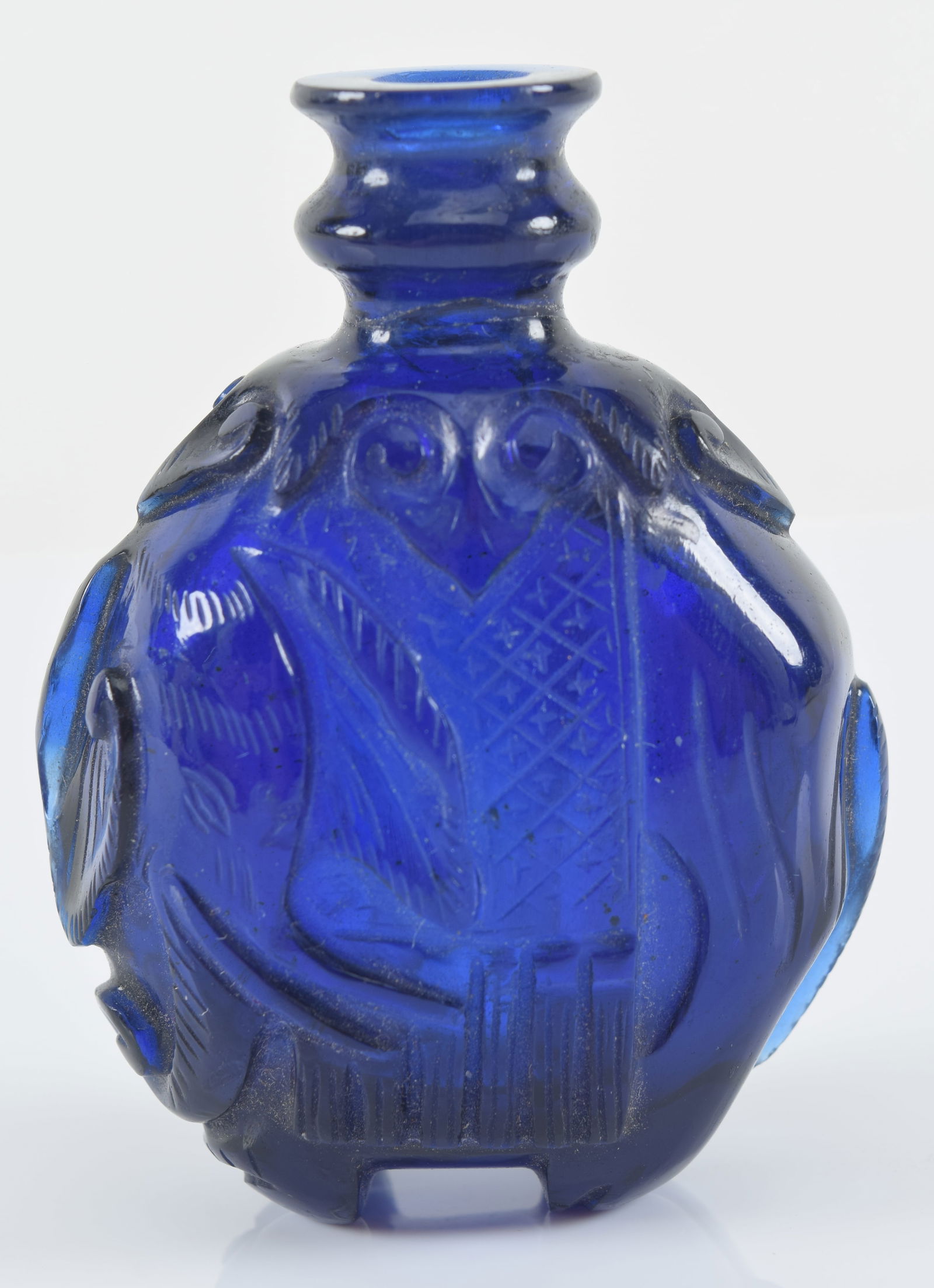 Peking glass snuff bottle. China. 19th century. Clear sapphire blue. Carved as a caparisoned (1 of 6)