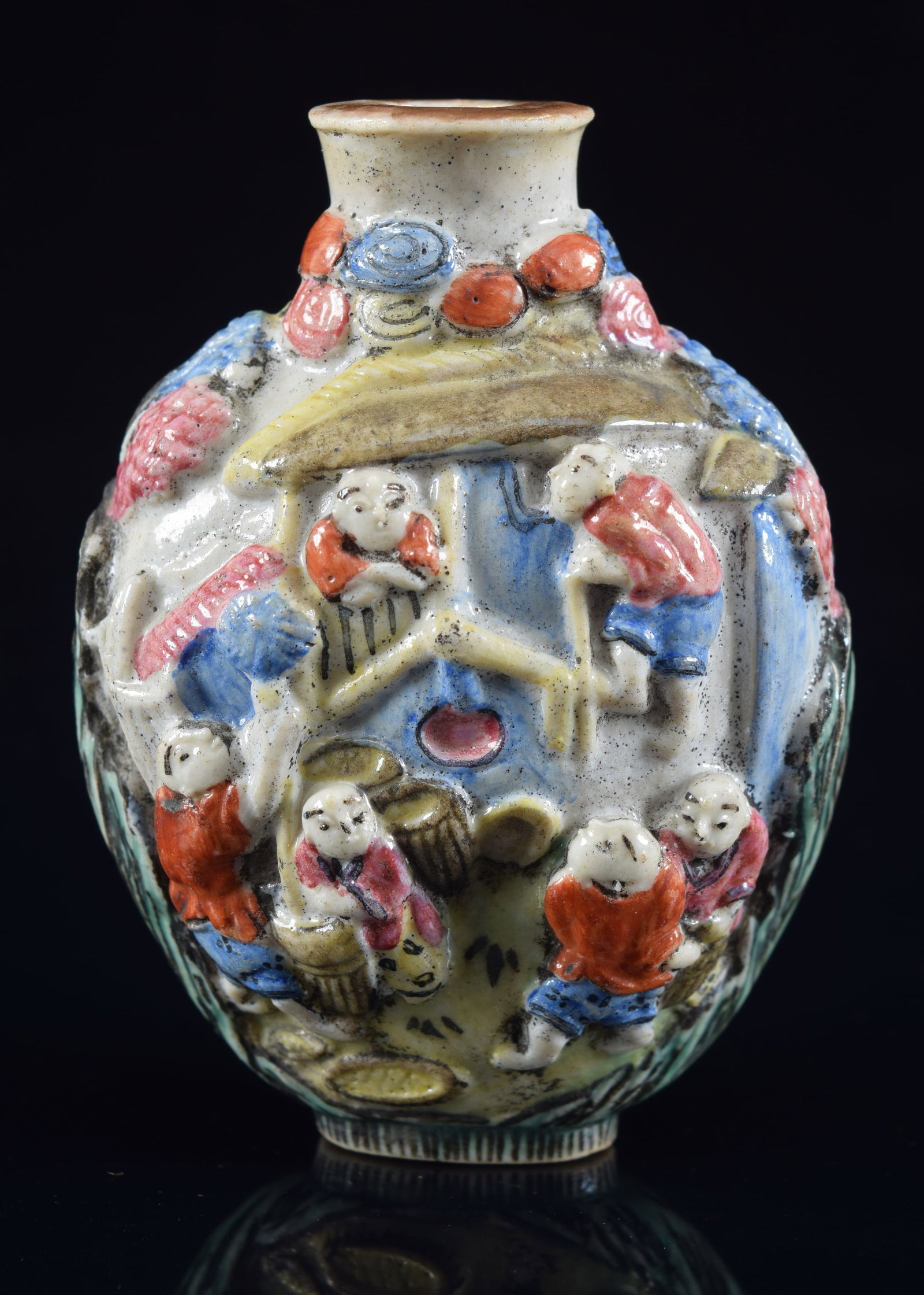 Porcelain snuff bottle. China. 19th century. Polychrome moulded decoration of an manufacturing: Porcelain snuff bottle. China. 19th century. Polychrome moulded decoration of an manufacturing scene. Chien Lung mark. Small chip. 3in H. Provenance: The Mitchell Bistany Collection.