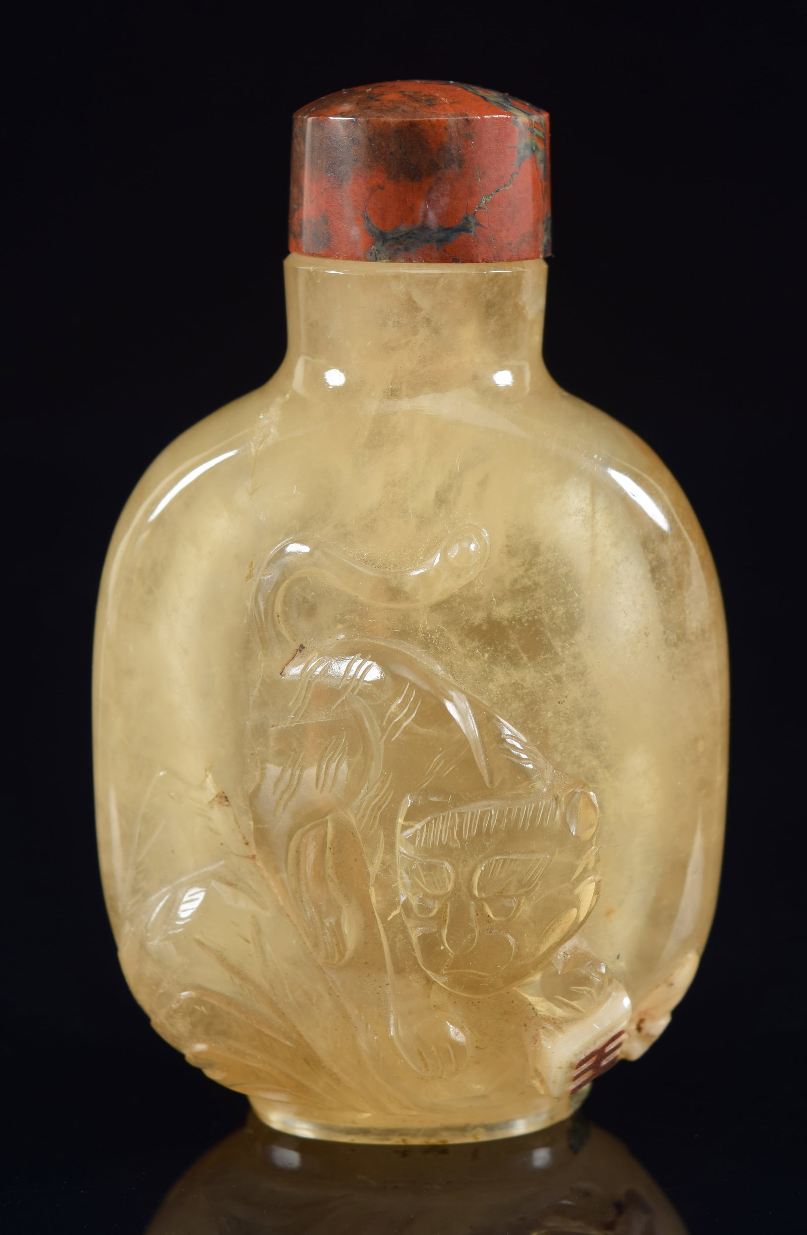 Crystal snuff bottle. China. 19th century. Tan colored. Surface carved with a tiger and dragon.: Crystal snuff bottle. China. 19th century. Tan colored. Surface carved with a tiger and dragon. Bloodstone stopper. 2.5in H. Provenance: The Mitchell Bistany Collection.