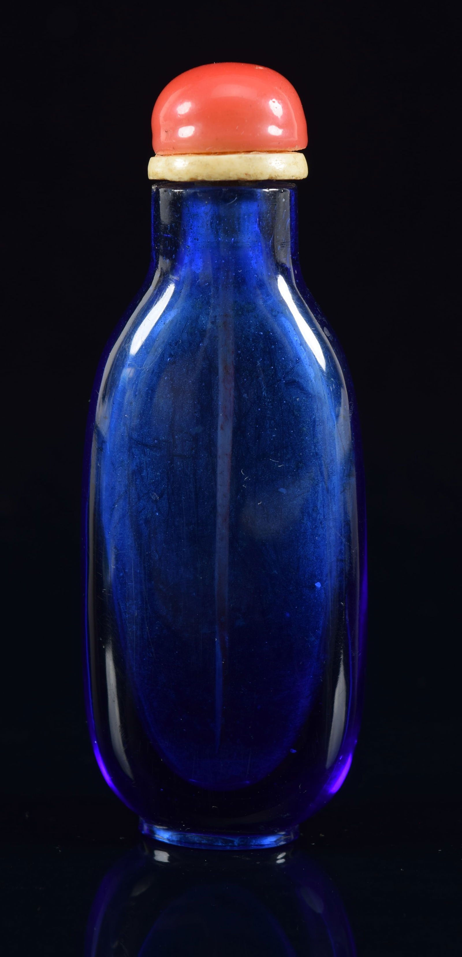 Peking glass snuff bottle. Sapphire blue color. Coral stopper. 3in H. Provenance: The Mitchell (1 of 6)
