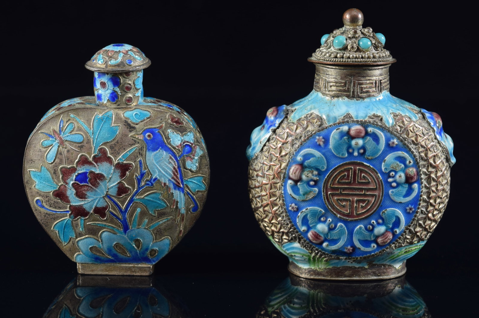 2 enameled snuff bottles. China. Early 20th century. Silvered copper with repousse birds and flowers: 2 enameled snuff bottles. China. Early 20th century. Silvered copper with repousse birds and flowers with blue, purple, turquoise and green surfaces. 3 and 2.75in H. Provenance: The Mitchell Bistany C
