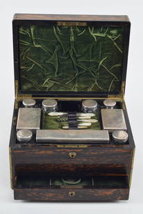 English Sterling silver cased traveling dresser set, London 1864-65. The brass bound box with exotic: English Sterling silver cased traveling dresser set, London 1864-65. The brass bound box with exotic grained and brass inlaid monogram. Maker's label J. Southcombe, 130 &131 Jermyn St, London. The top