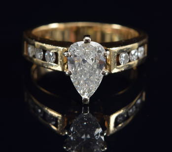 14K gold pear shape diamond ring. Stone approximately 1.3ct measuring approx. 9.9 x 6.2mm. Central: 14K gold pear shape diamond ring. Stone approximately 1.3ct measuring approx. 9.9 x 6.2mm. Central stone surrounded by 3 small round cut diamonds on each side in a pierced gold setting. Unmarked.